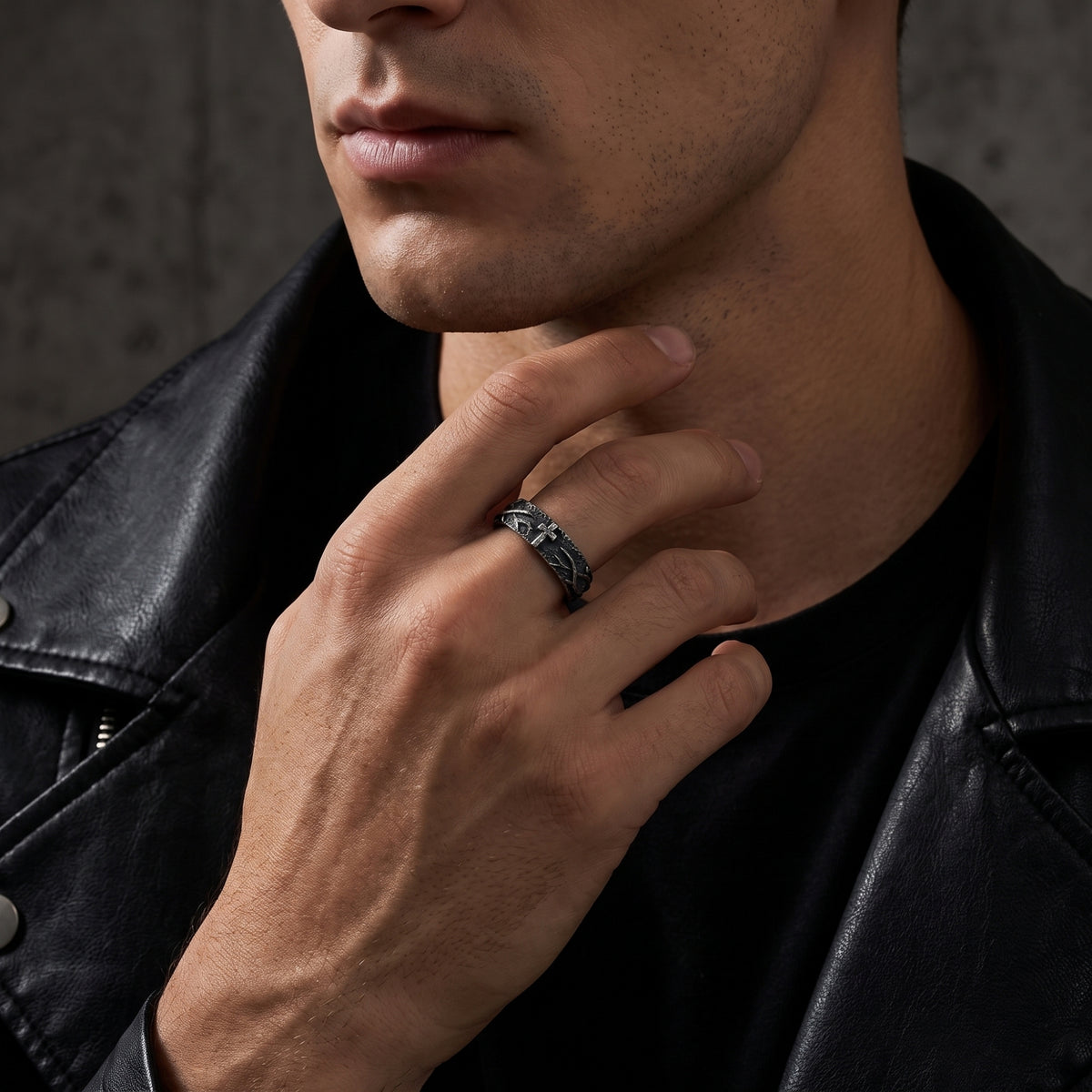Model wearing the silver cross ring on his middle finger with a black leather jacket