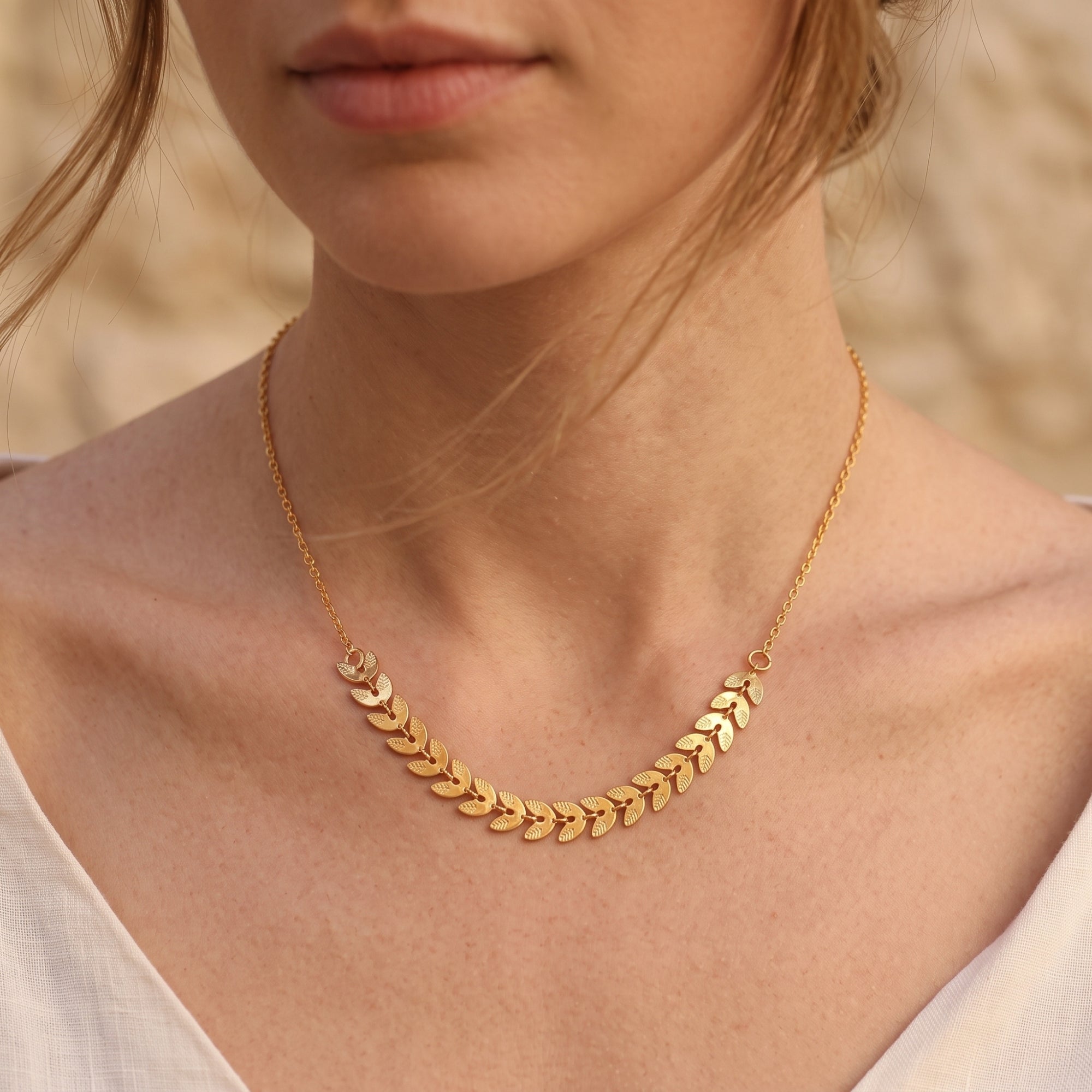 Front view of the gold leaf statement necklace on a model.