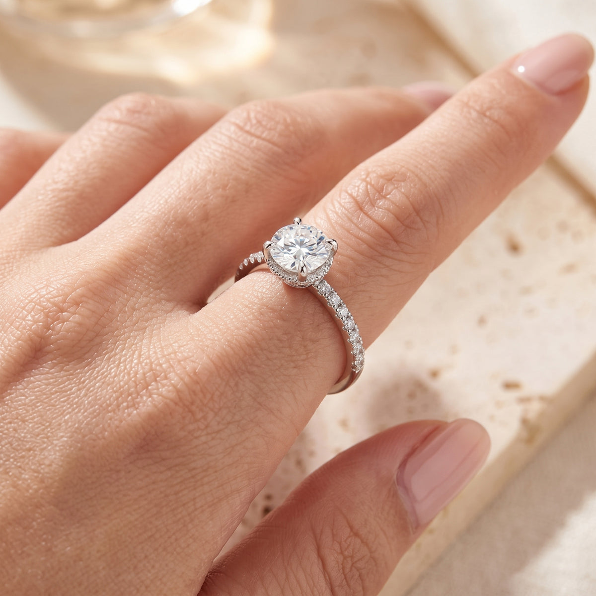 Close-up of the Elorina sterling silver promise ring with a 6.5mm round simulated diamond worn on a finger.