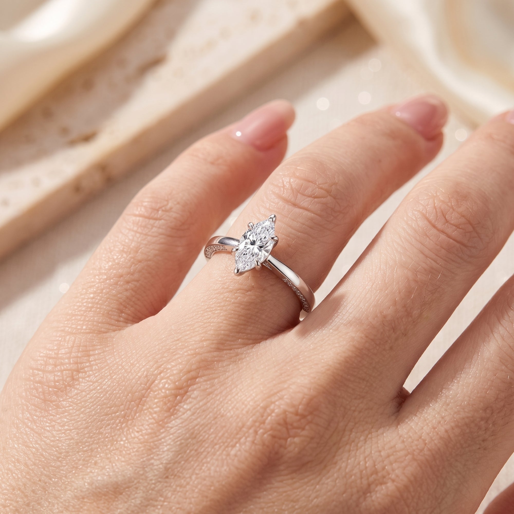 Marquise-cut simulated diamond ring in sterling silver shown on a finger to illustrate size and fit.