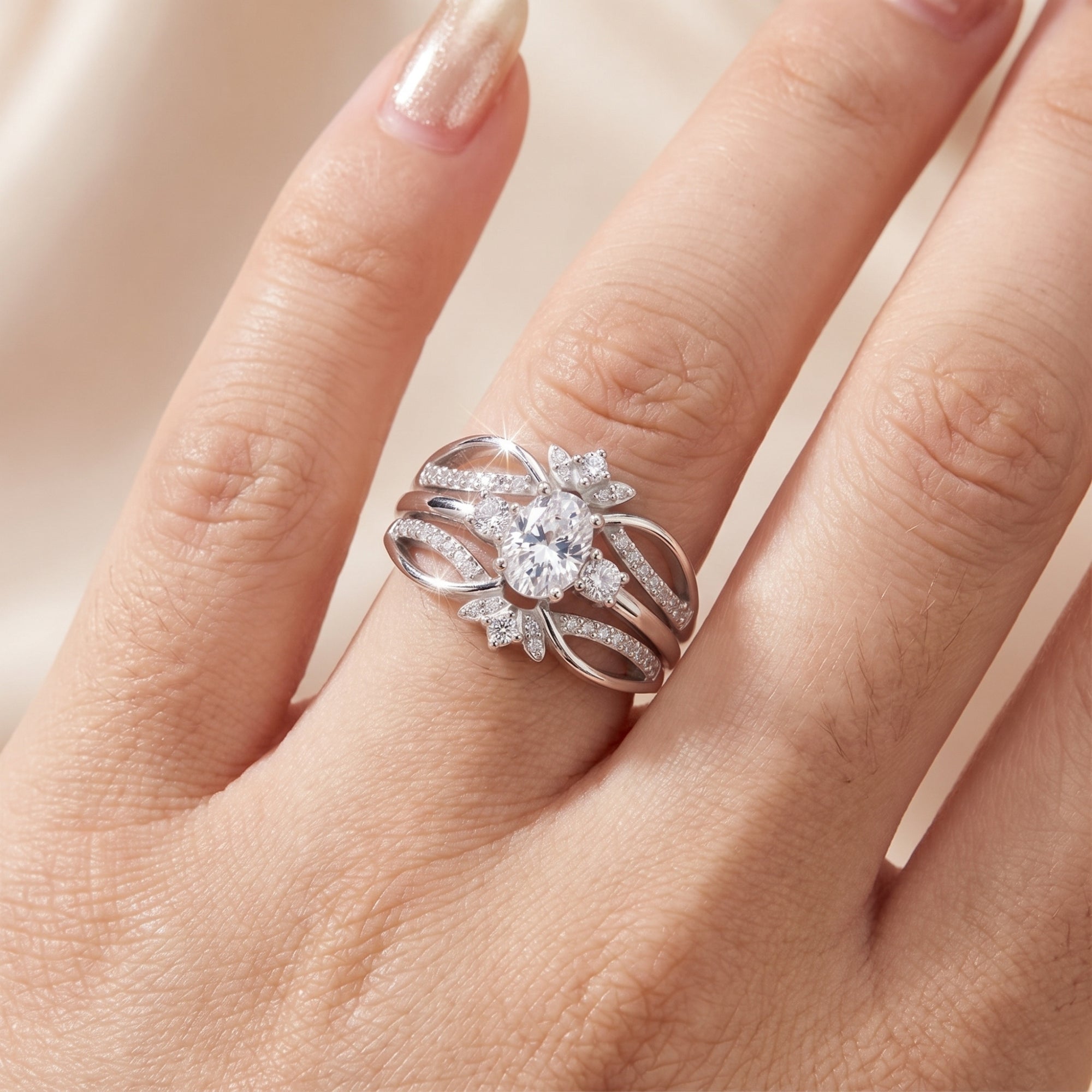 Close-up of an oval-cut simulated diamond ring in sterling silver on a model's hand.