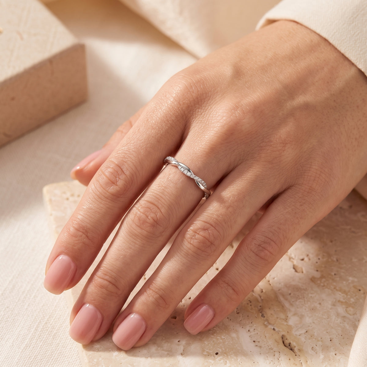 Veronelle silver twisted band ring with pavé simulated diamonds shown on a hand for a low-profile fit.