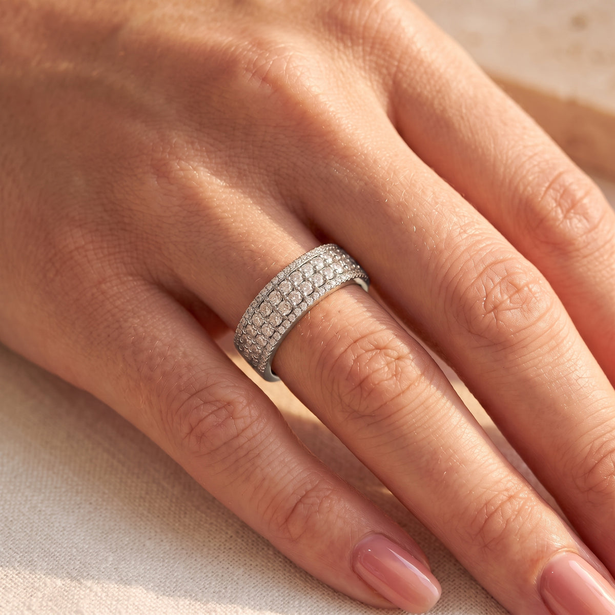 Sterling silver multi-row cubic zirconia promise ring shown on a finger for scale and fit.