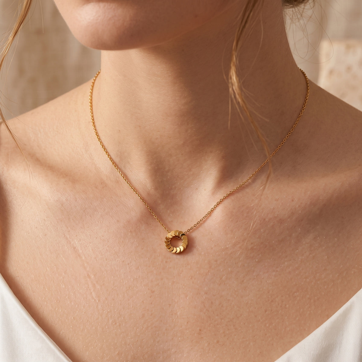 Front view of the Freya 18K gold plated necklace on a model's neck.