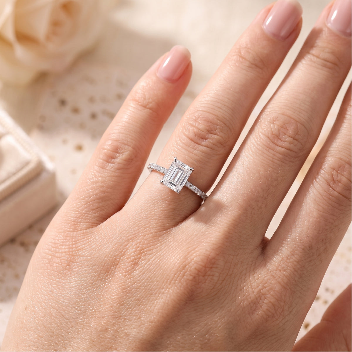 Top view of the emerald-cut simulated diamond ring in sterling silver on a finger for scale.