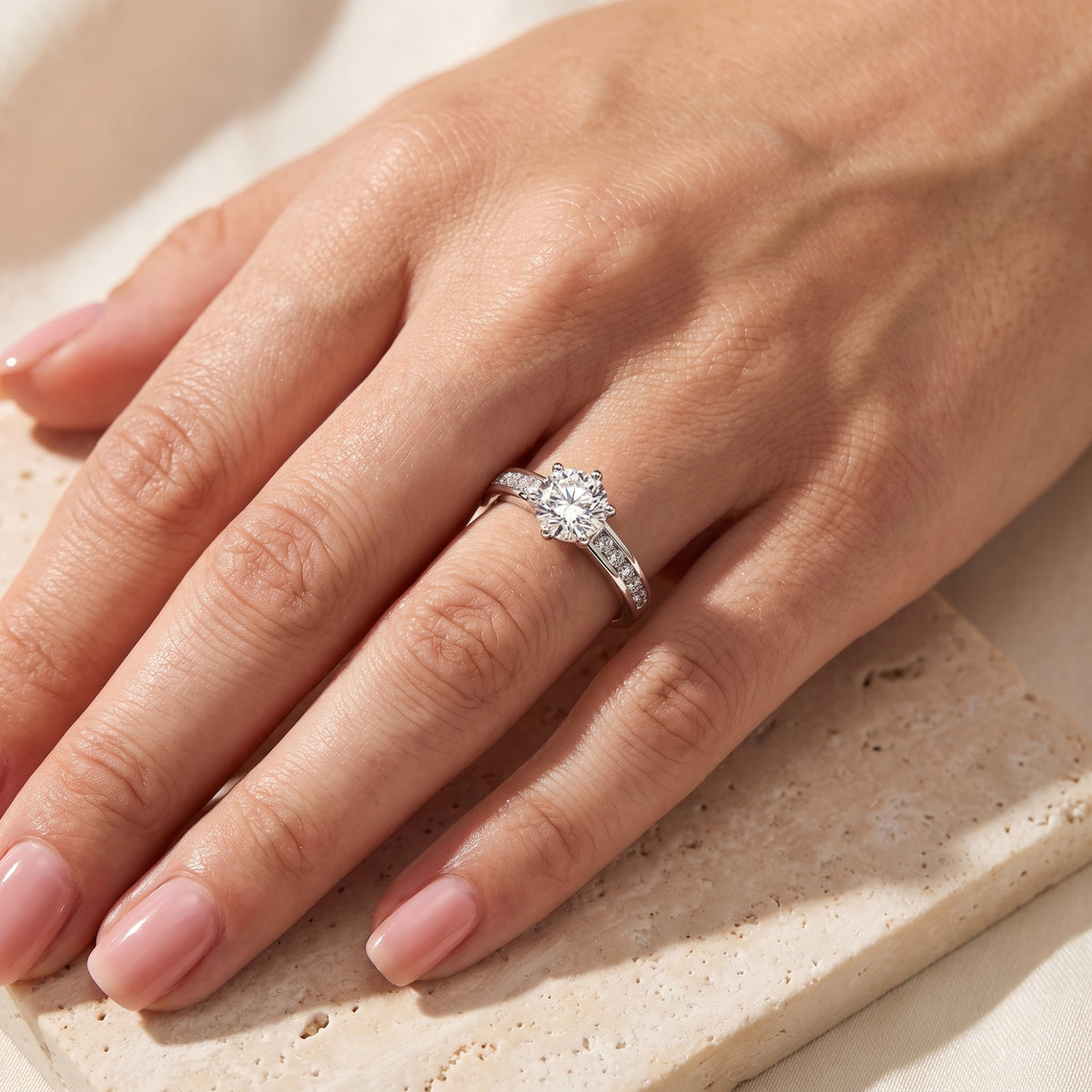Top-down hand view showing the silver channel-set solitaire ring worn on the ring finger.
