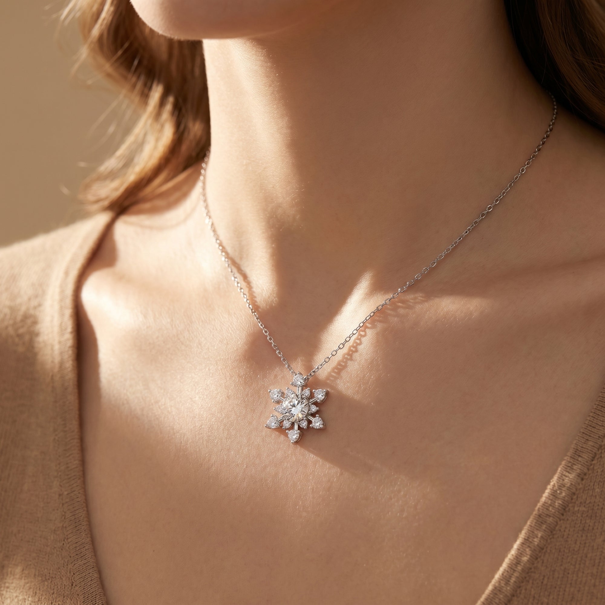 Sterling silver moissanite snowflake necklace worn by a model in a lifestyle setting.