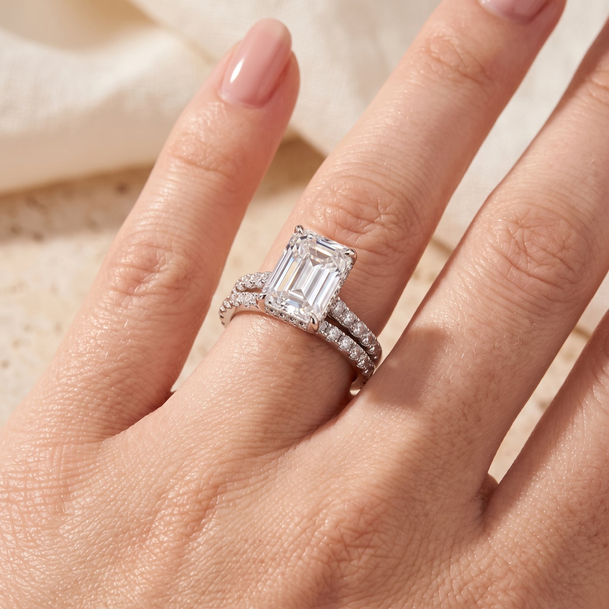 Macro view of the sterling silver emerald-cut simulated diamond ring set on a model's finger.
