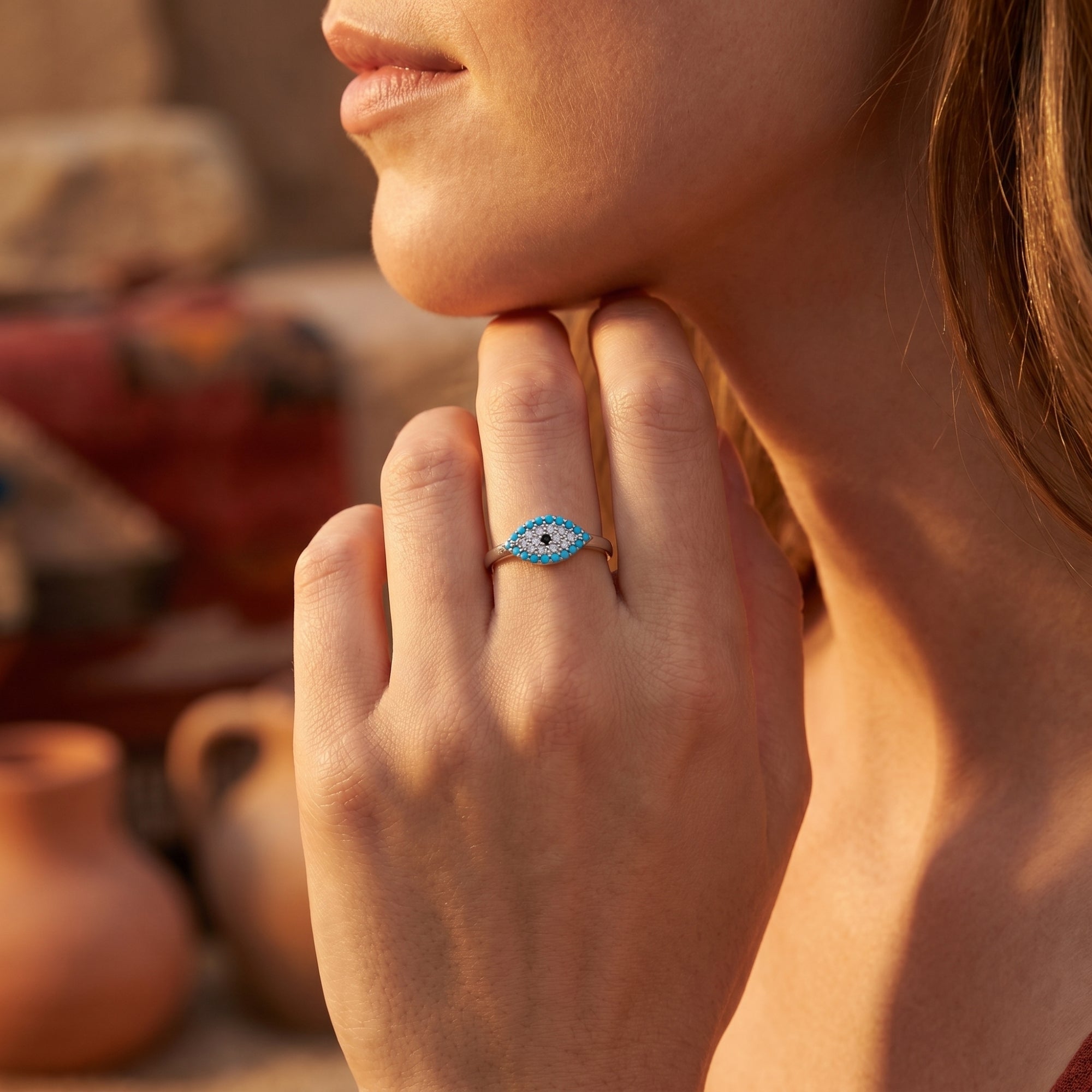 Silver turquoise evil eye ring worn by a model, showcasing its delicate design and vibrant blue stones.