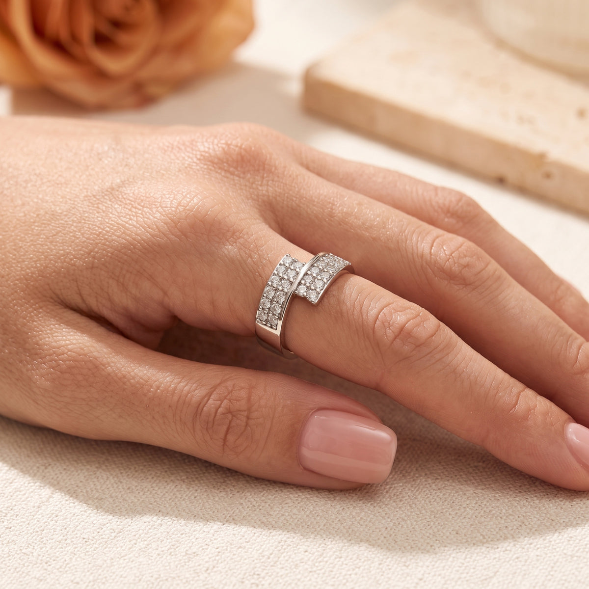 Side profile of the sterling silver Eldria bypass promise ring with simulated diamonds on a model's hand.