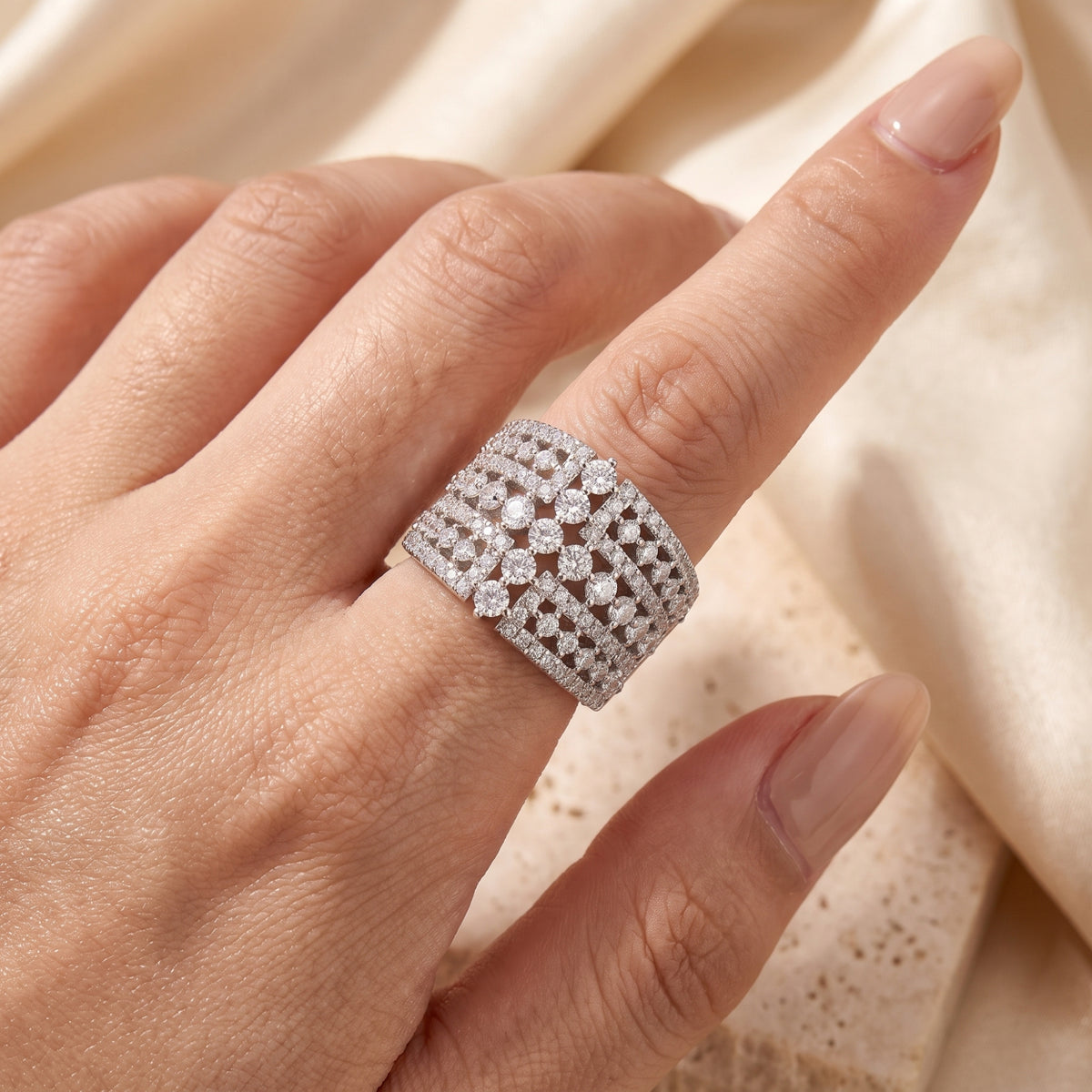 Close-up of the multi-row sterling silver band with precision-set simulated diamond crystals on a finger.
