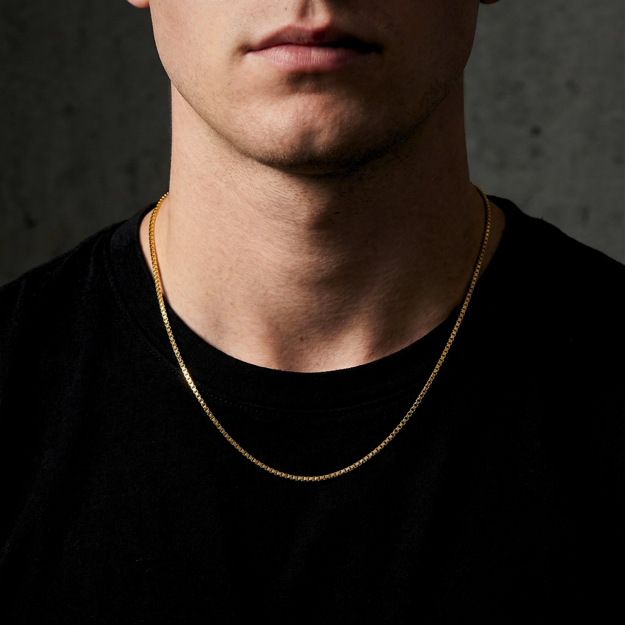 Frontal view of a man wearing the 18k gold bonded stainless steel Boxed In chain over a black shirt.