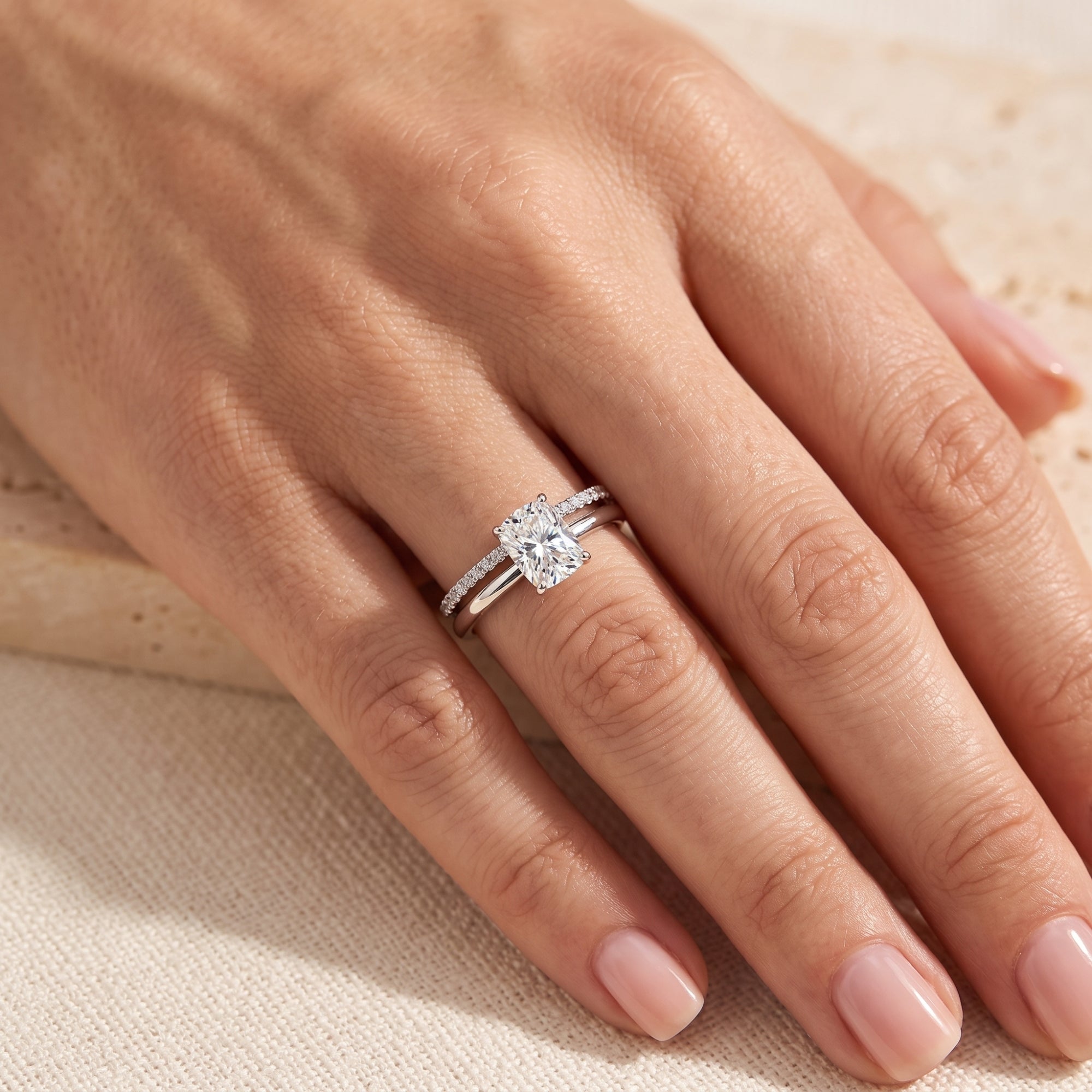 Sterling silver double-band ring set with emerald-cut stone on a hand.