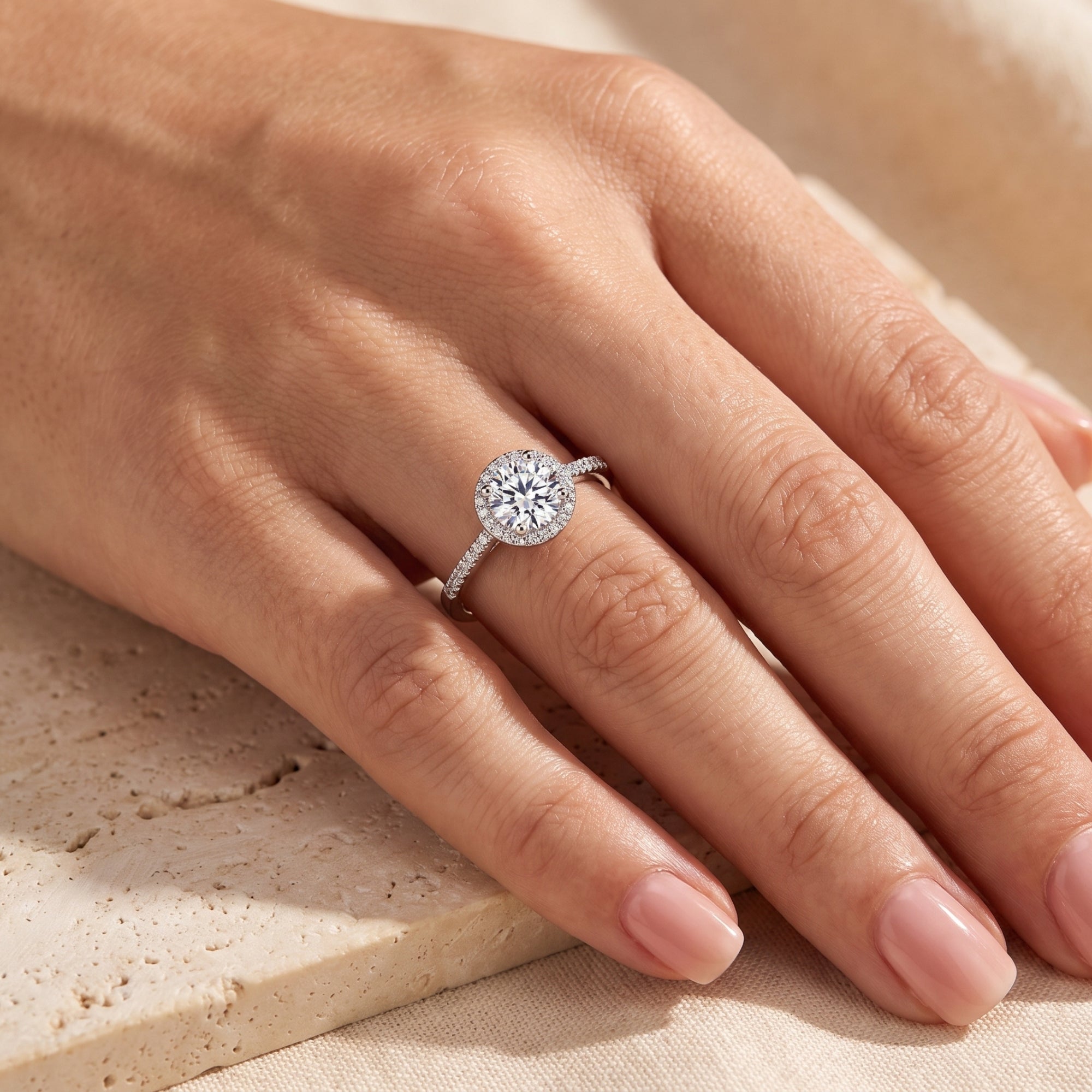 Top-down view of the sterling silver Cassielle halo ring with a round-cut simulated diamond on a finger.