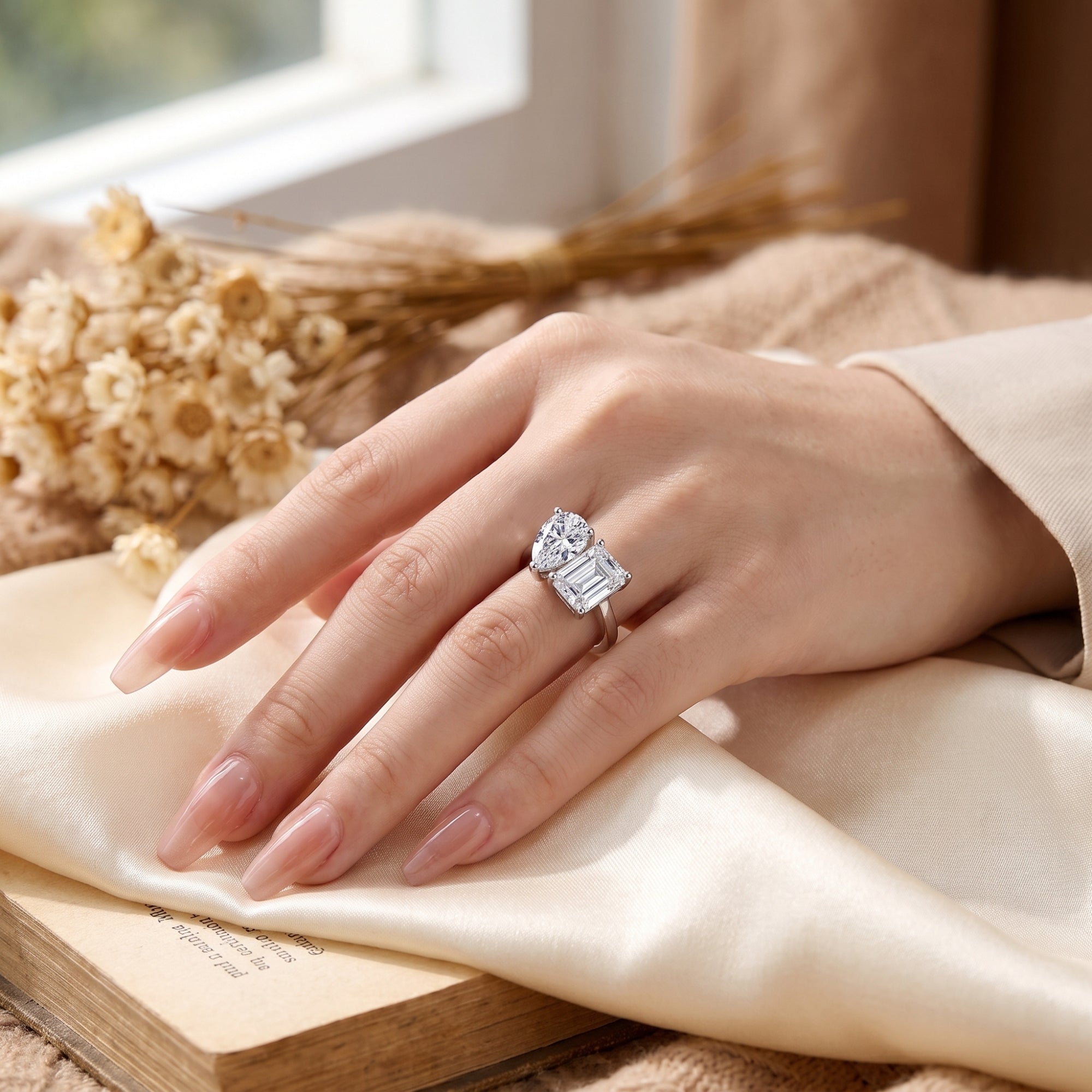 Sterling silver Toi et Moi bypass ring with simulated diamonds worn on a hand in a cozy lifestyle setting.