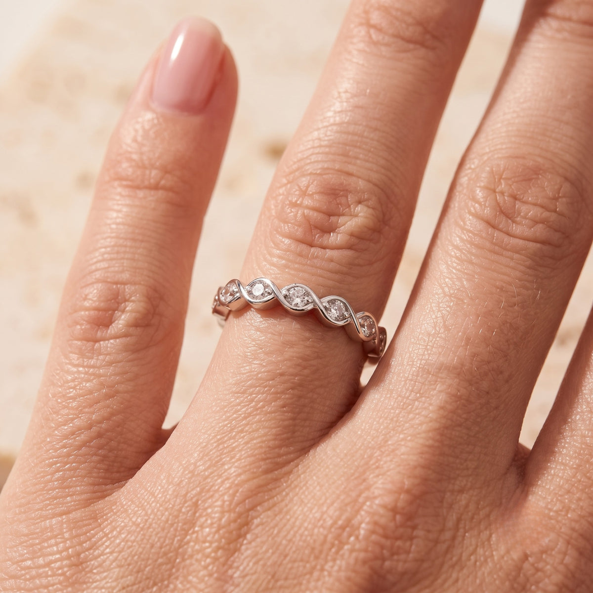 Top-down view of the Amandelle sterling silver wave ring on a finger to show scale and fit.