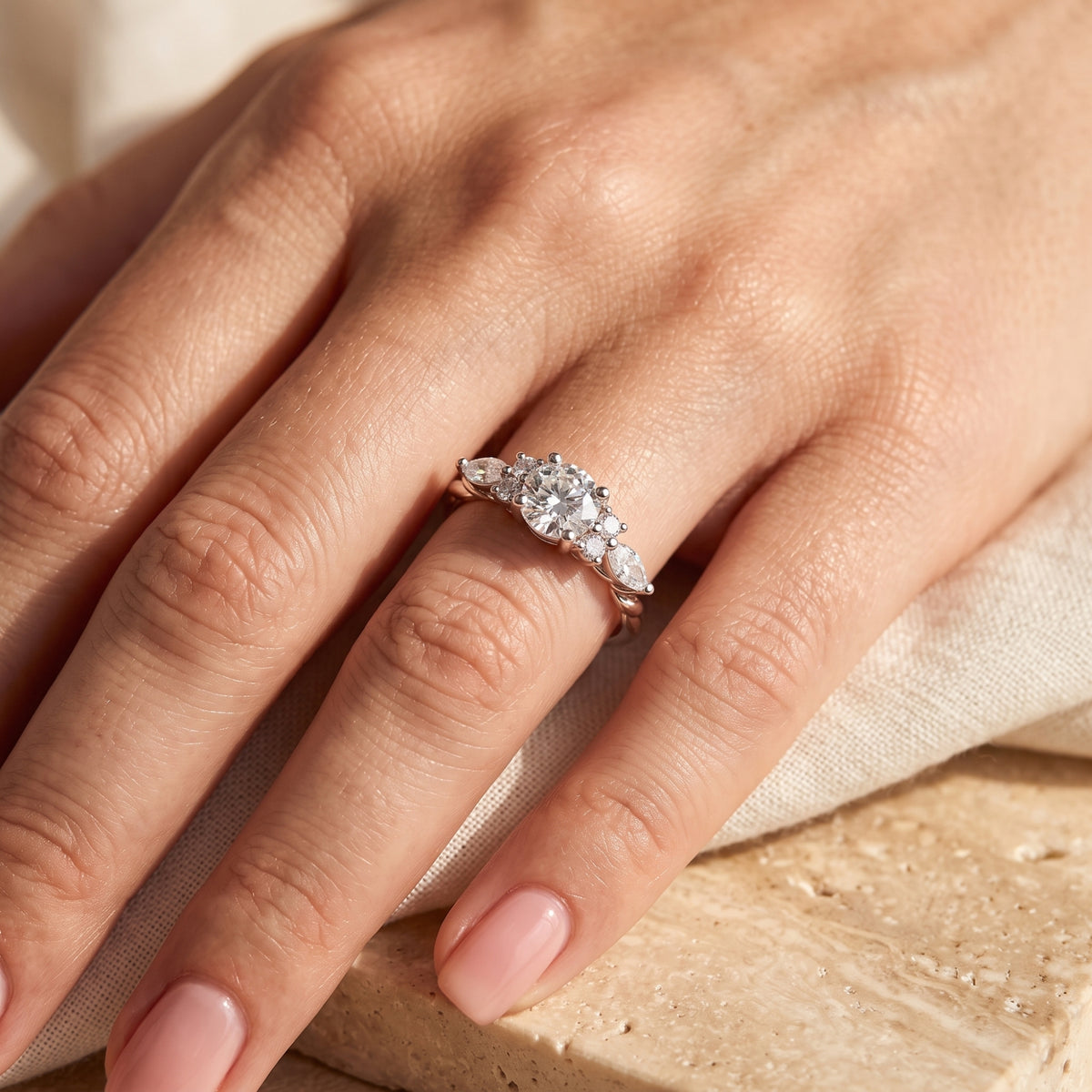 Close-up of The Carlotta Ring, a solid gold ring with brilliant simulated diamonds, on a model's finger.
