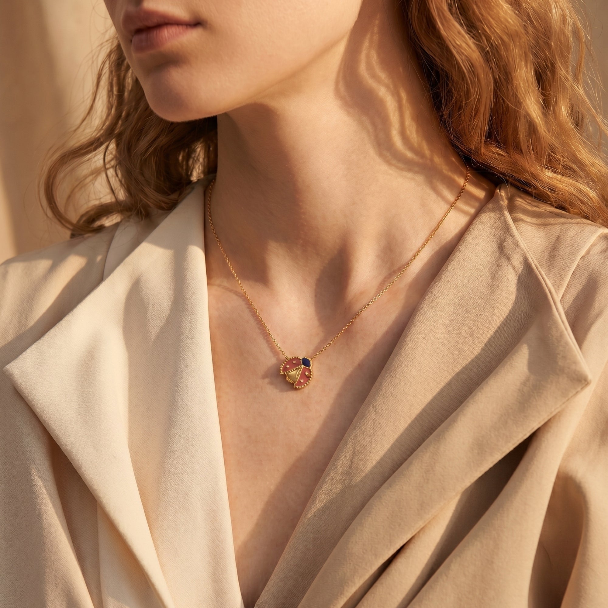 Gold finish ladybug necklace styled on a model.
