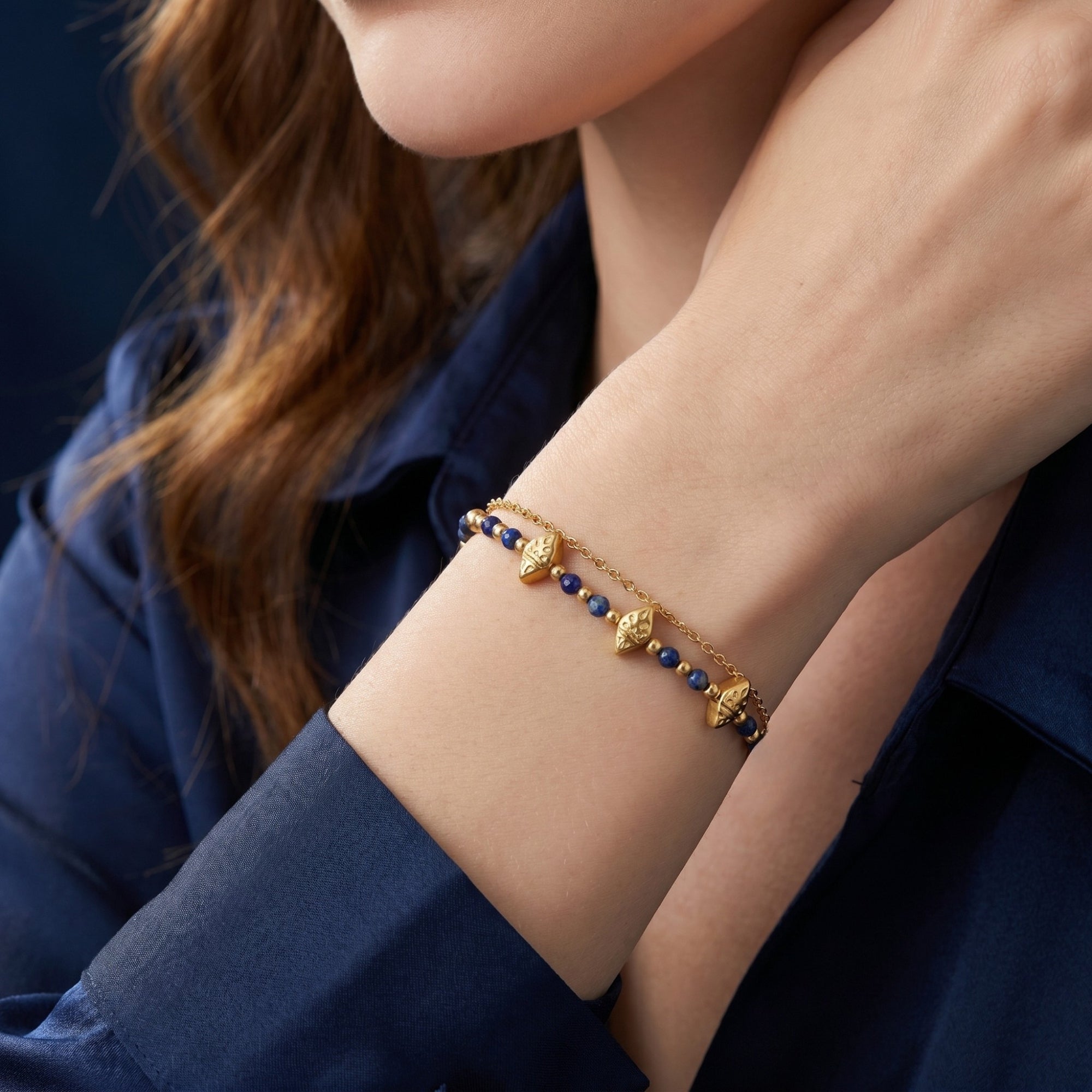 Model wearing the adjustable 18k gold-plated lapis bead bracelet, showcasing the delicate double-chain design.