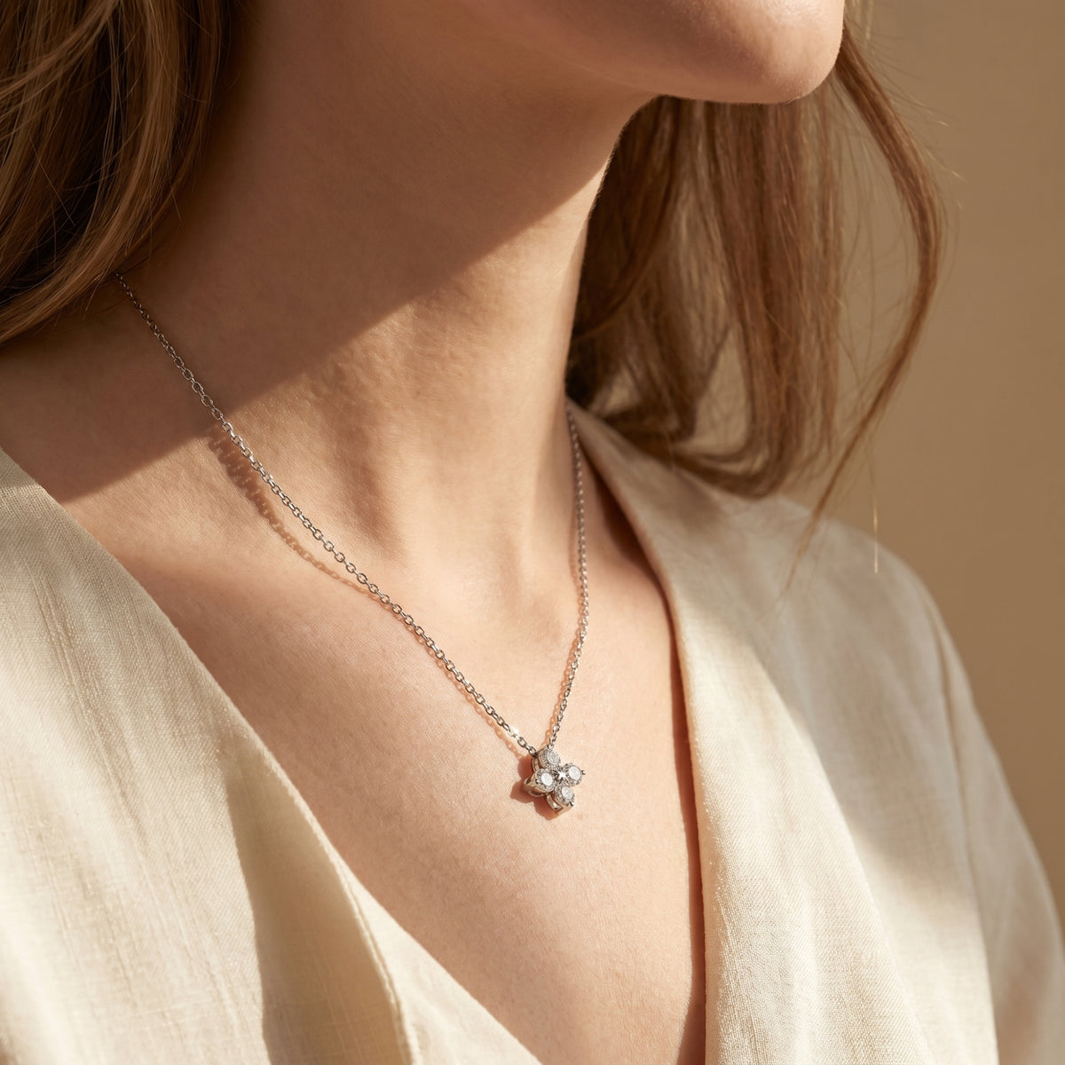 Silver moissanite flower pendant necklace worn by a model in soft natural lighting.