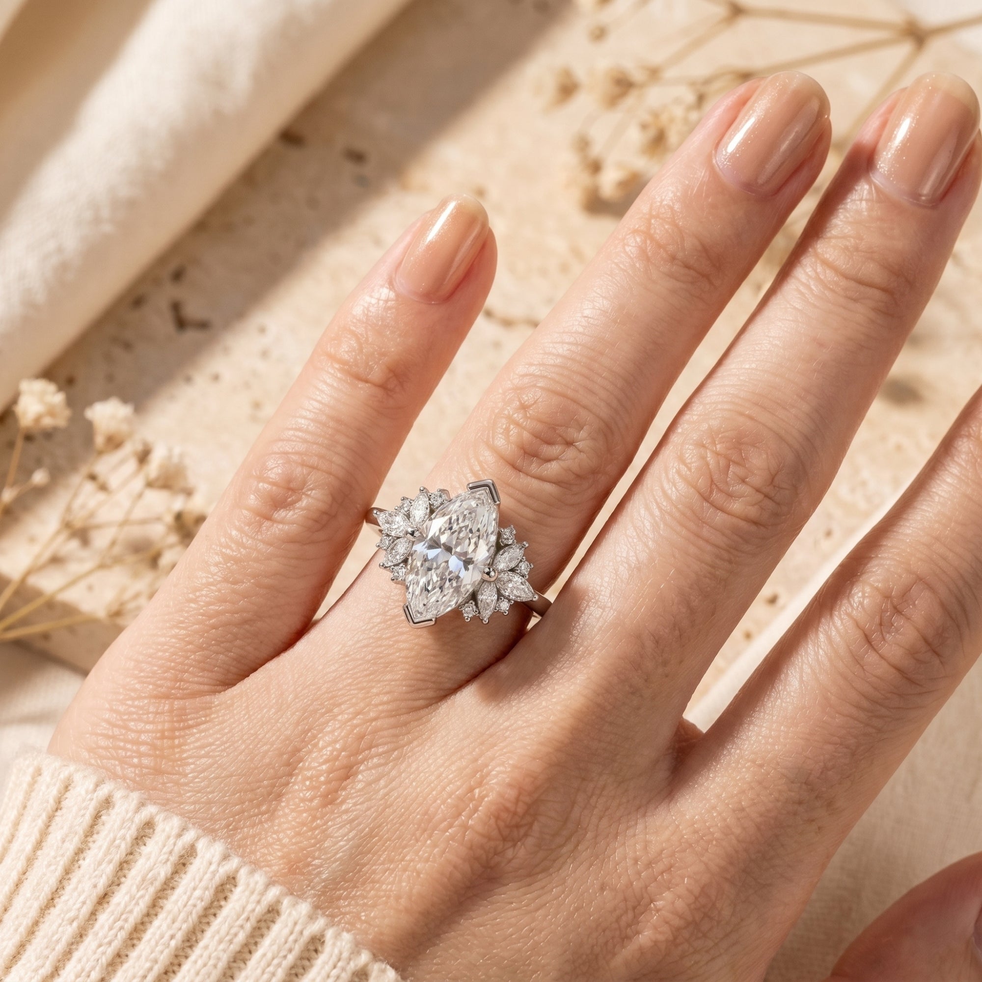 Top-down view of a silver marquise moissanite promise ring worn on a finger for scale reference.