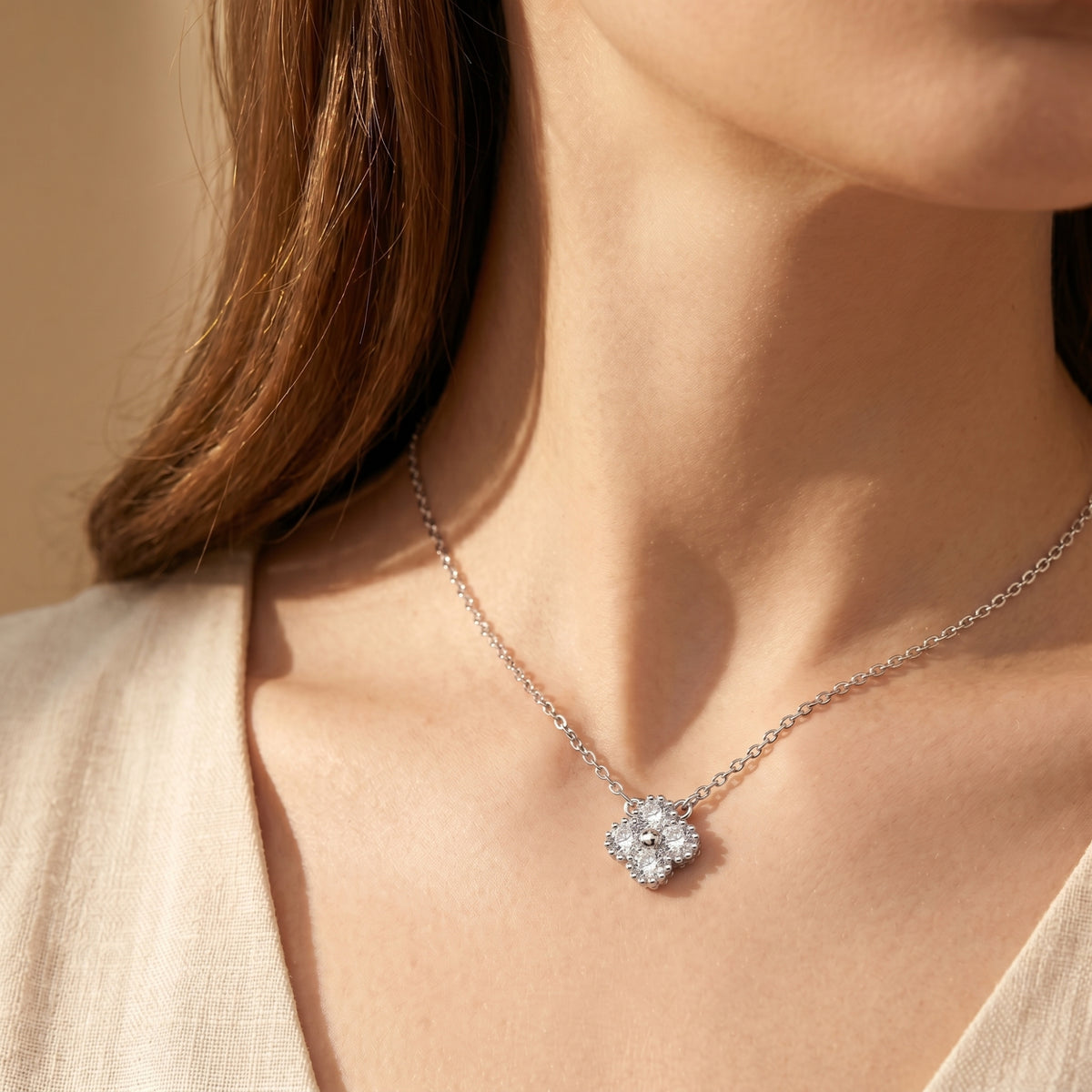 Silver clover moissanite necklace worn on model.