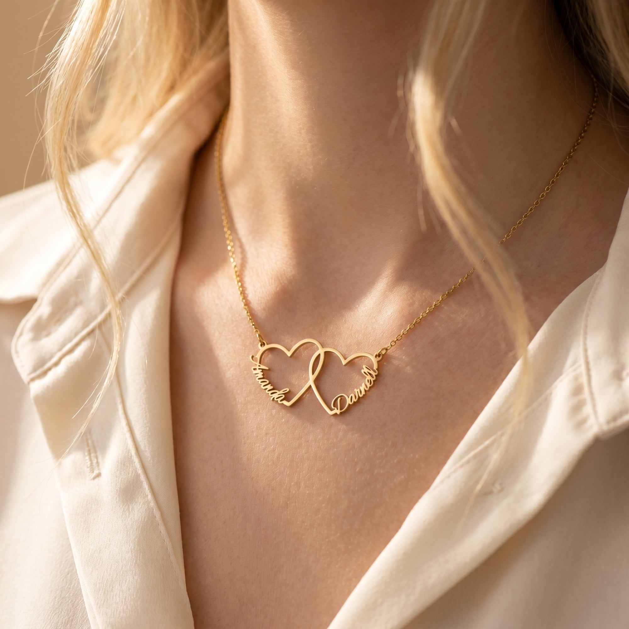 Gold stainless steel interlocking heart necklace worn by model.