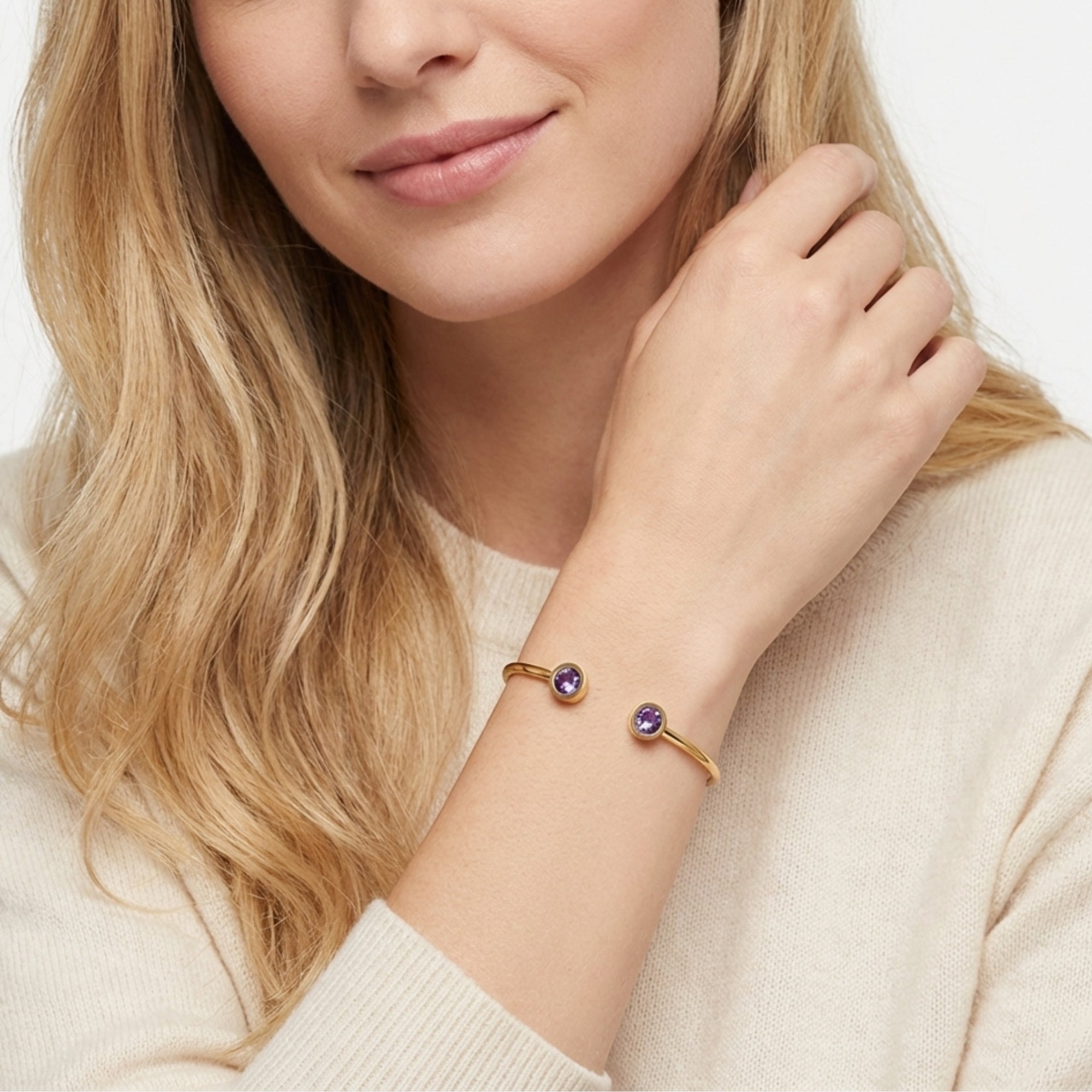 Gold stainless steel Liora open-cuff bracelet with round purple amethyst stones on a woman's wrist.