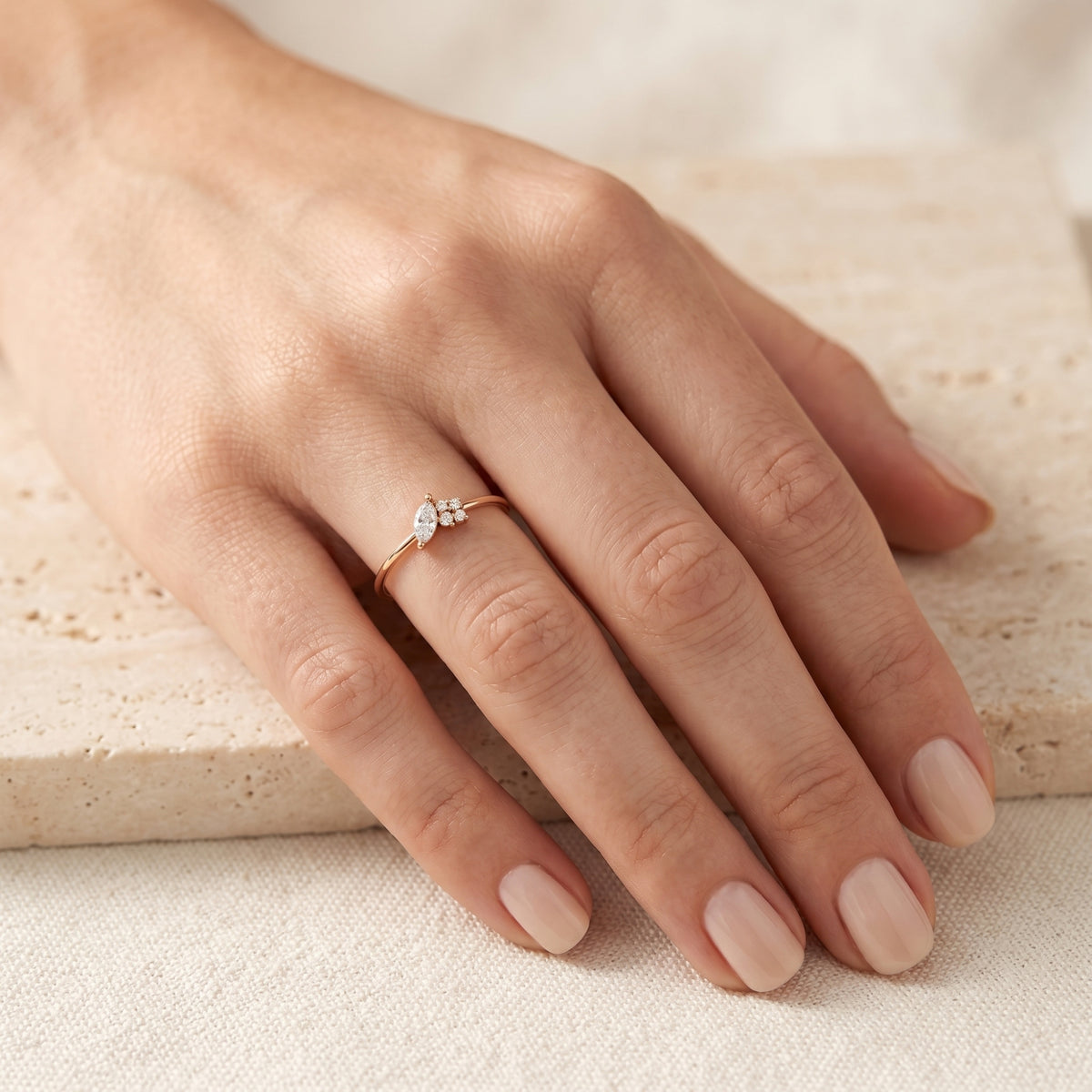 Rose gold marquise moissanite ring worn on a finger.