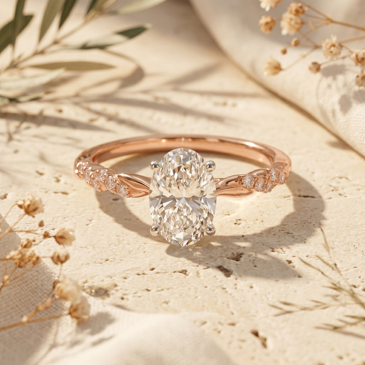 Rose gold oval moissanite ring on stone with flowers.