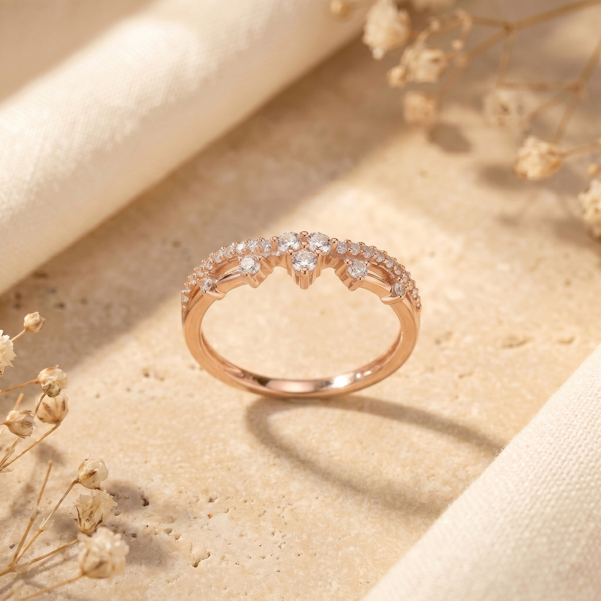 Rose gold Ismerelle tiara ring featuring brilliant simulated diamonds on a warm-toned lifestyle background.