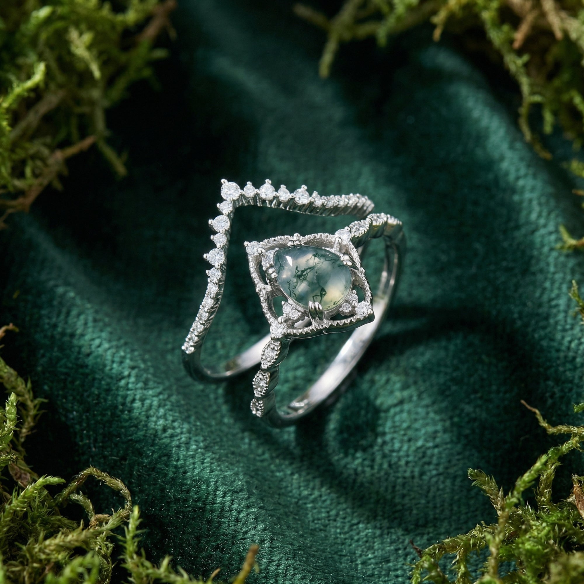 Two-piece sterling silver ring set featuring an oval cut moss agate and a diamond-encrusted chevron band on moss.