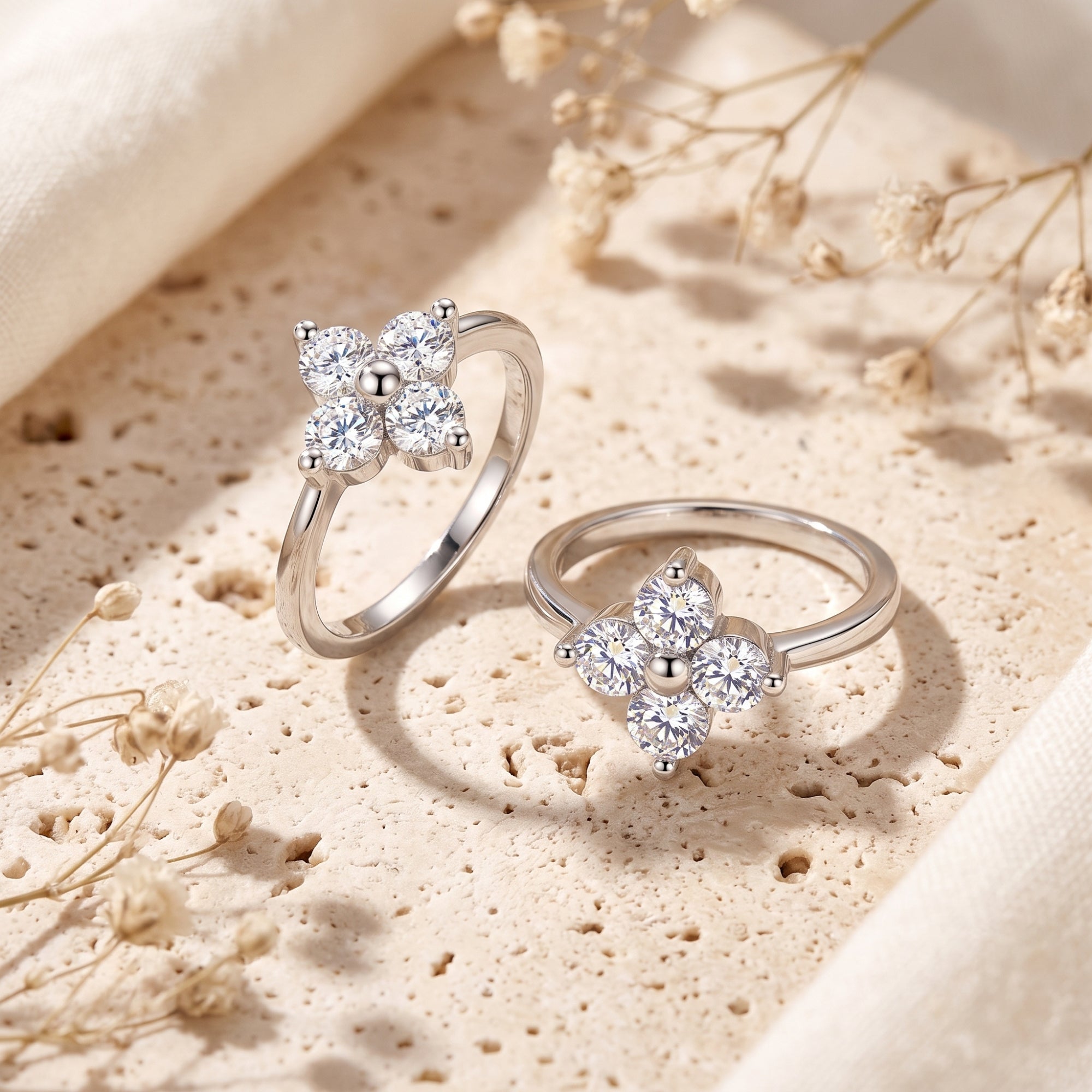 Two sterling silver Fleurienne clover rings with round cubic zirconia on a lifestyle stone surface.