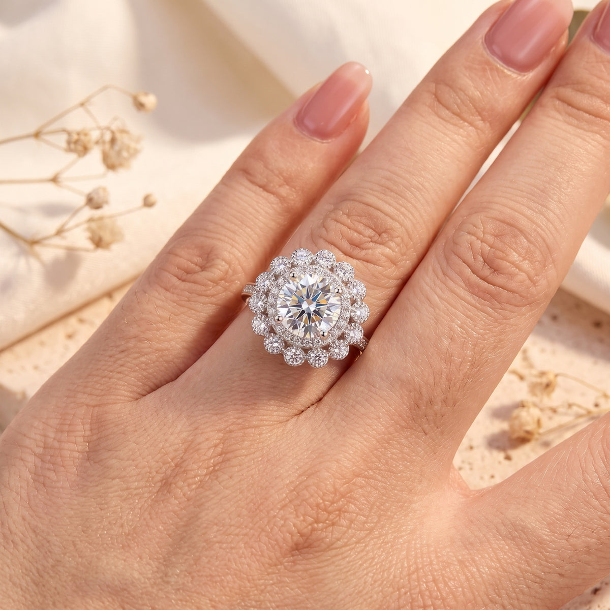 Sterling silver Elysetta ring with a round simulated diamond halo shown on a finger for scale.