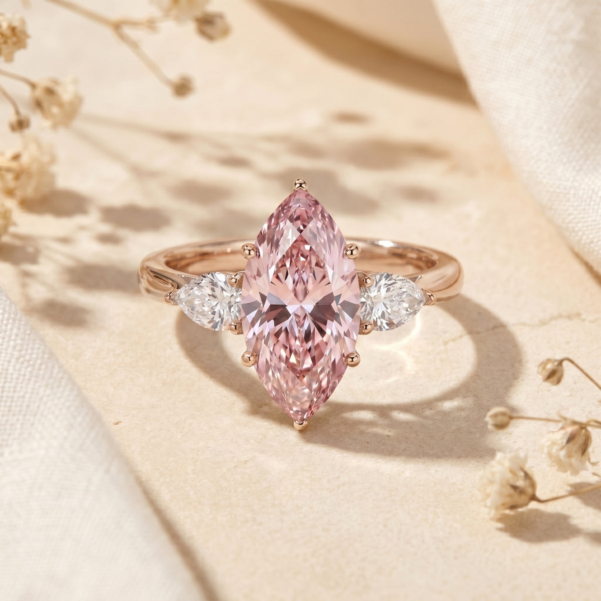 Marquise pink moissanite rose gold promise ring with pear side stones on a lifestyle background.