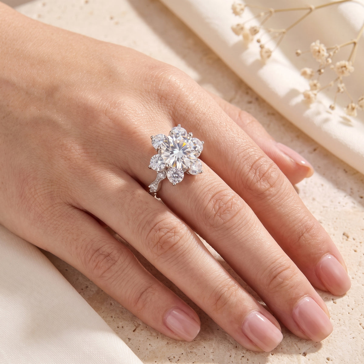 Roselita sterling silver simulated diamond ring on a hand showing the flower design and scale.