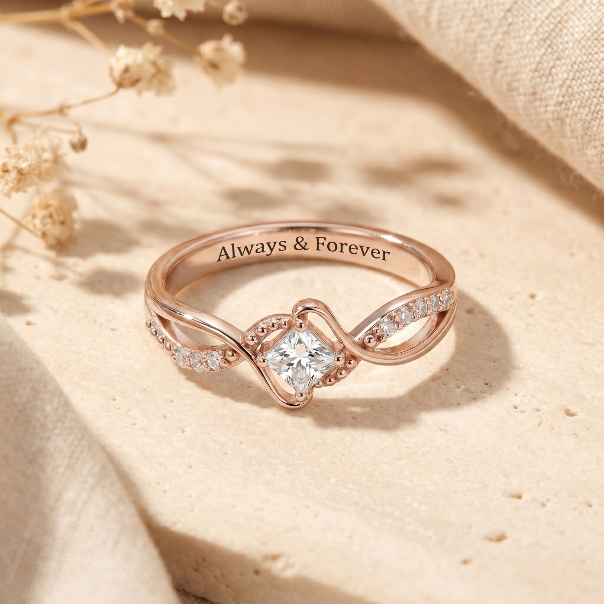 Rose gold princess cut moissanite promise ring with twisted band on lifestyle background.