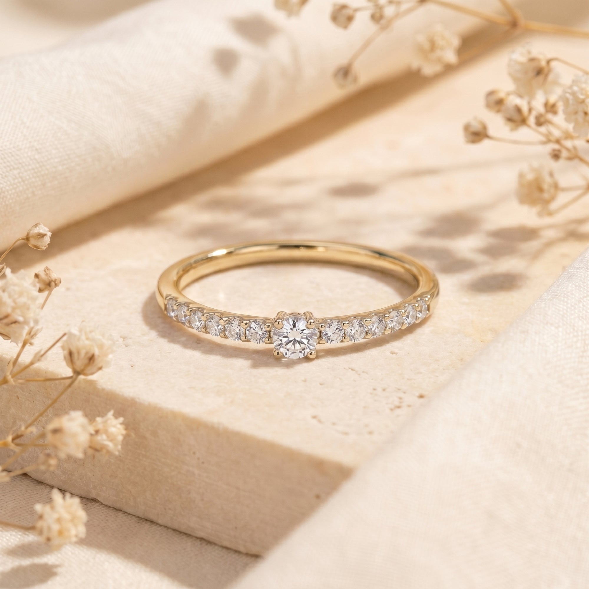 Yellow gold moissanite engagement ring with round center stone and pavé accents.