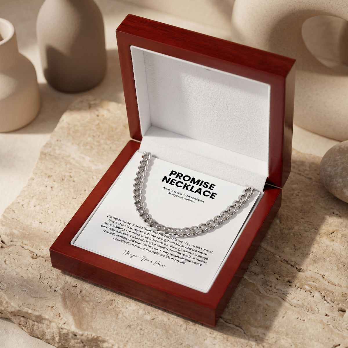 Silver-toned Cuban link necklace displayed in an open mahogany-style box over a printed message card.