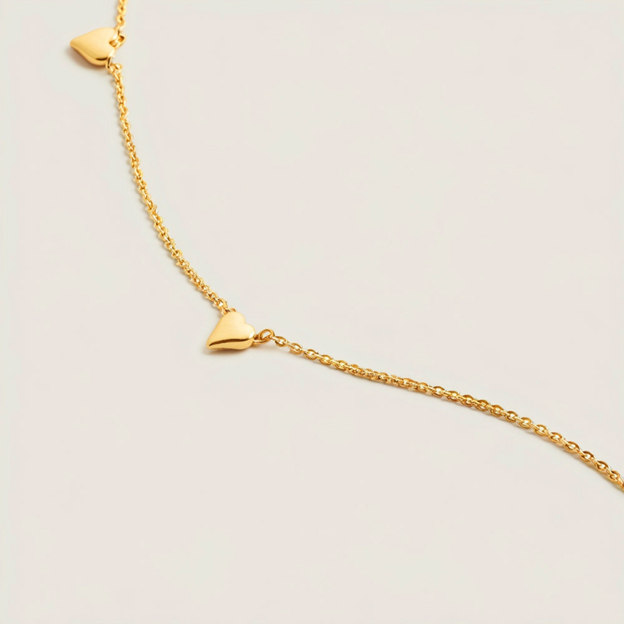 Solid gold necklace with spaced 6mm heart charms on an adjustable 40cm + 5cm chain