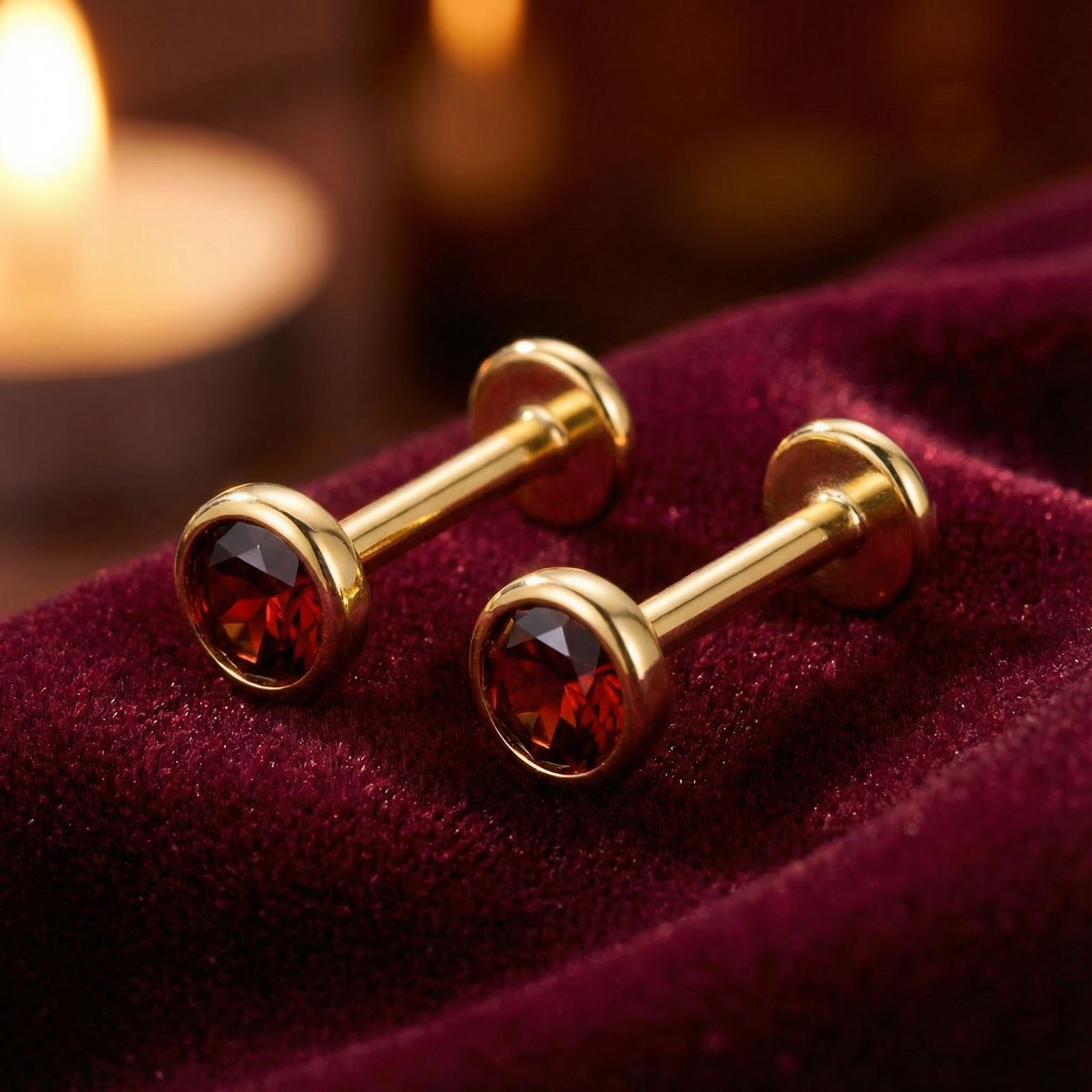 Side view of red simulated garnet stud earrings in 18K gold vermeil bezel settings showing flat back posts on velvet.