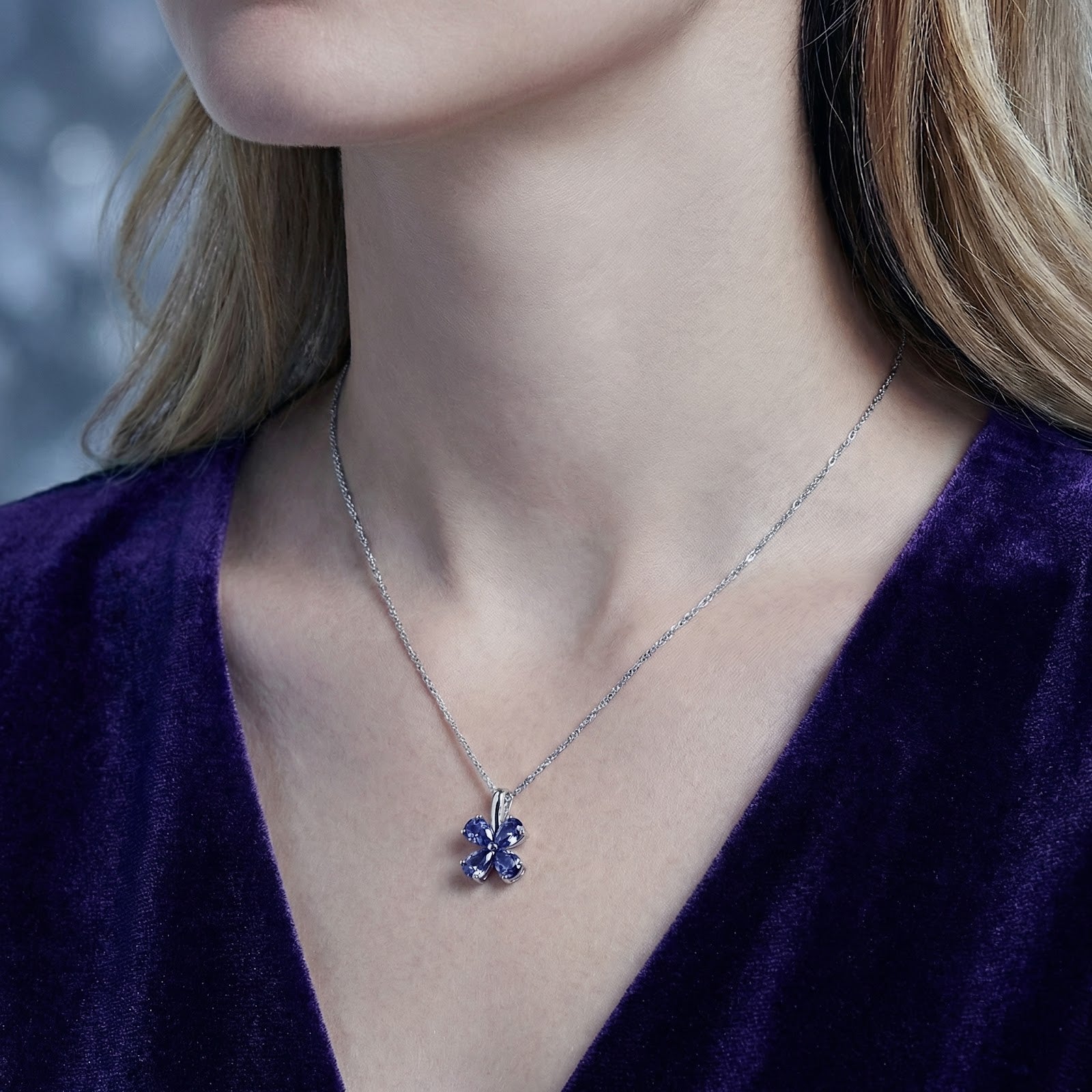 Model wearing the Sidraea Clover pear-cut simulated tanzanite necklace in S925 sterling silver with a purple dress.