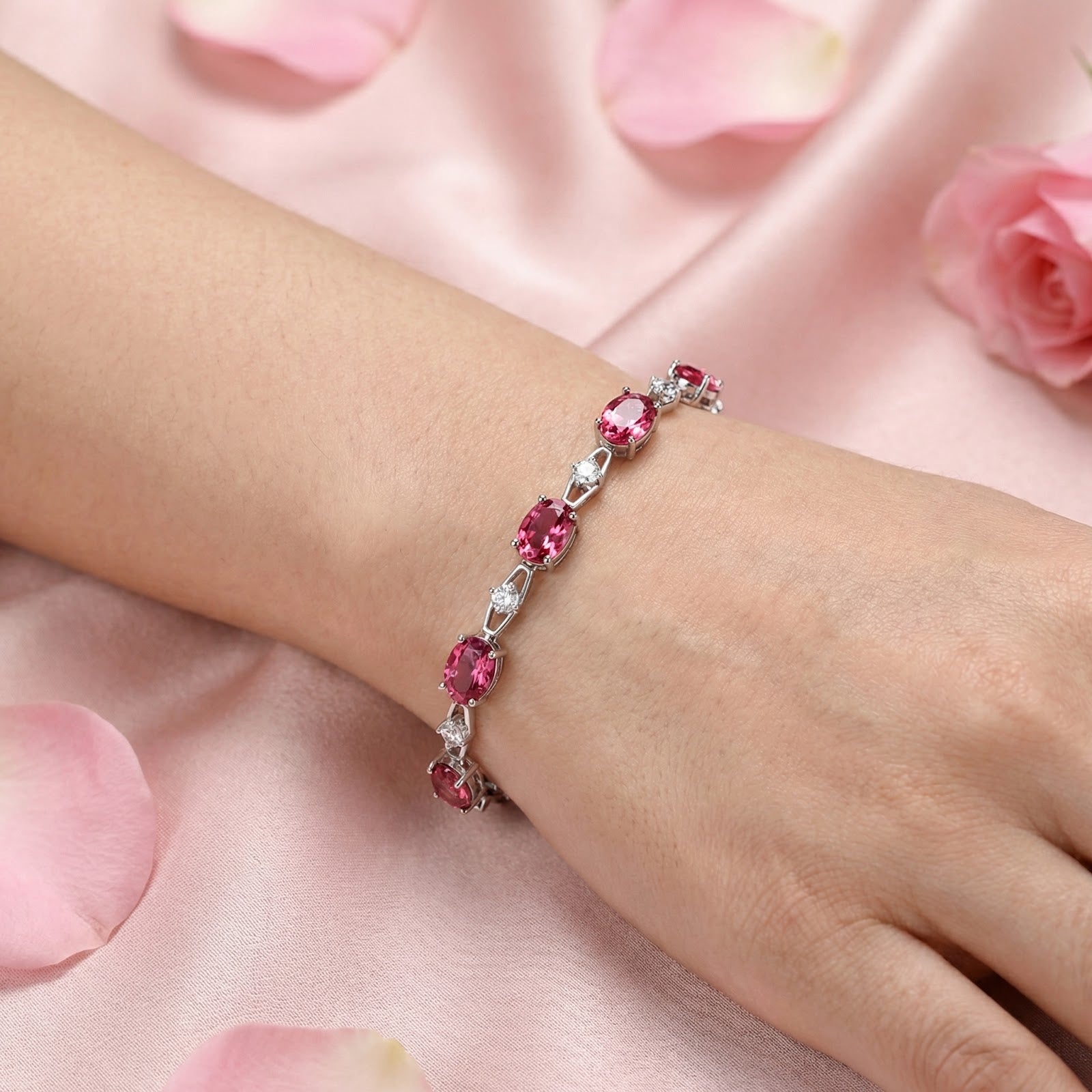 Nerisara sterling silver bracelet with oval pink tourmaline stones worn on a woman's wrist for scale.