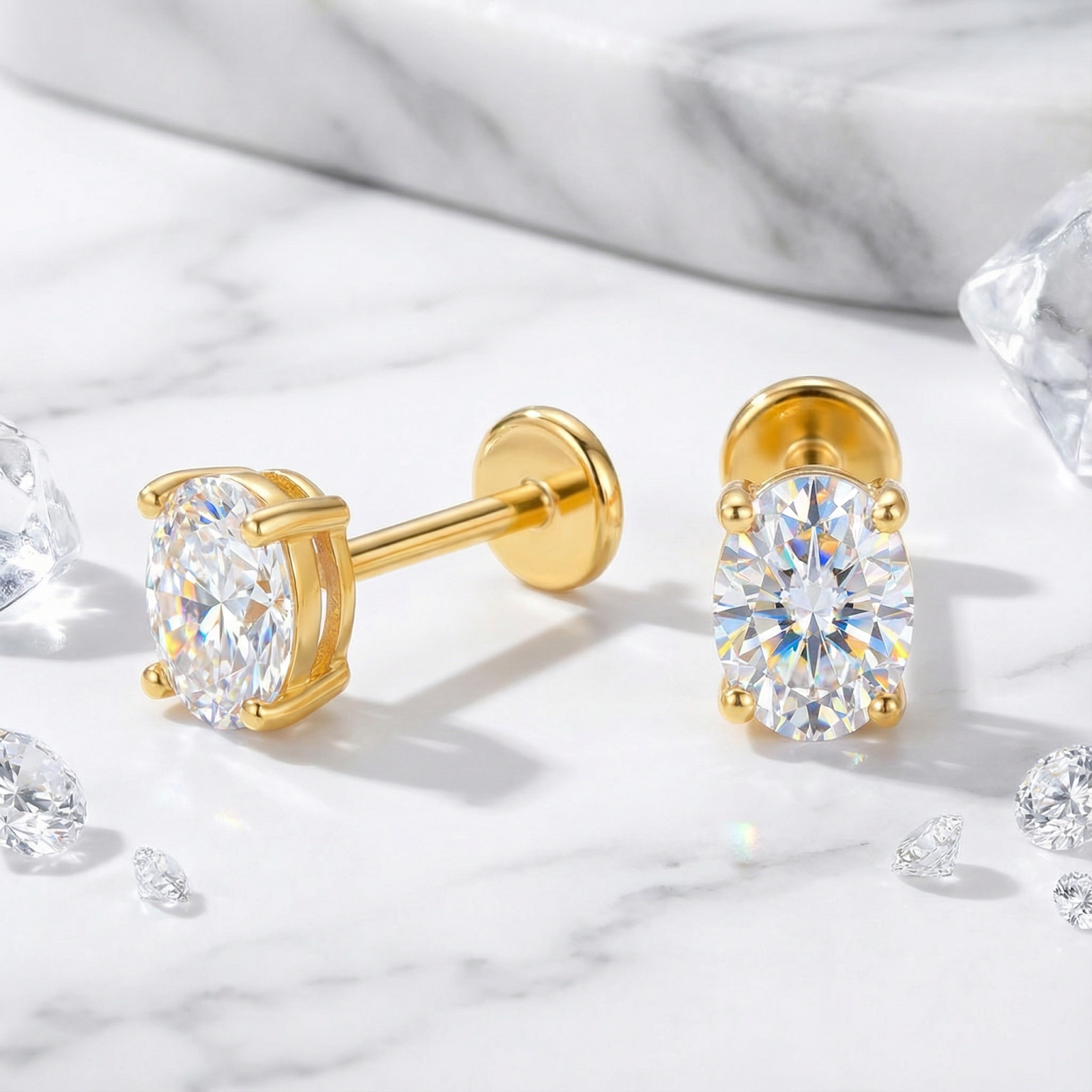 Oval cut zirconia stud earrings in 18K gold vermeil shown from front and side on marble.