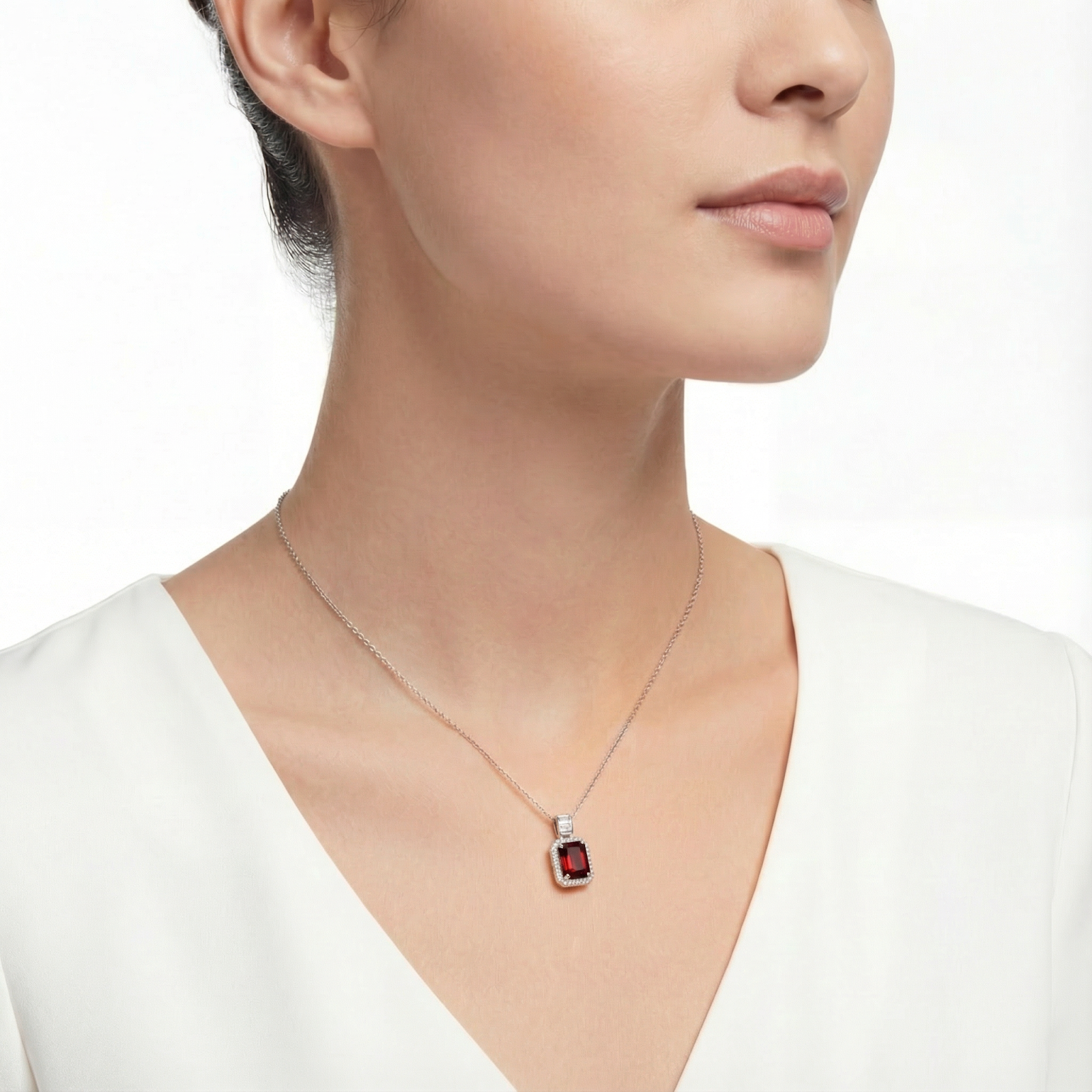 Deep red emerald-cut simulated garnet necklace in sterling silver worn by a model.