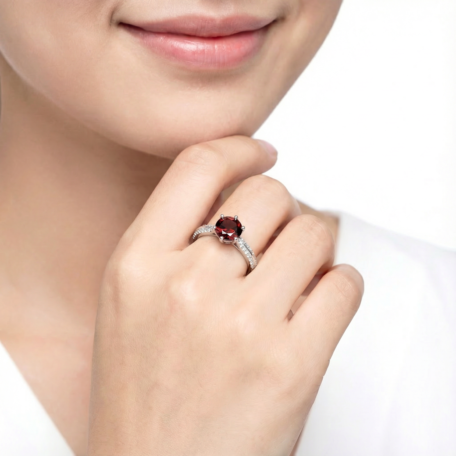 Sterling silver simulated garnet solitaire ring worn on a woman's hand against a clean white background.