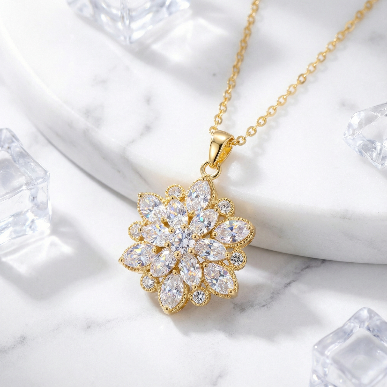 Gold stainless steel Dahlia Blossom necklace with marquise simulated diamonds on a marble surface.