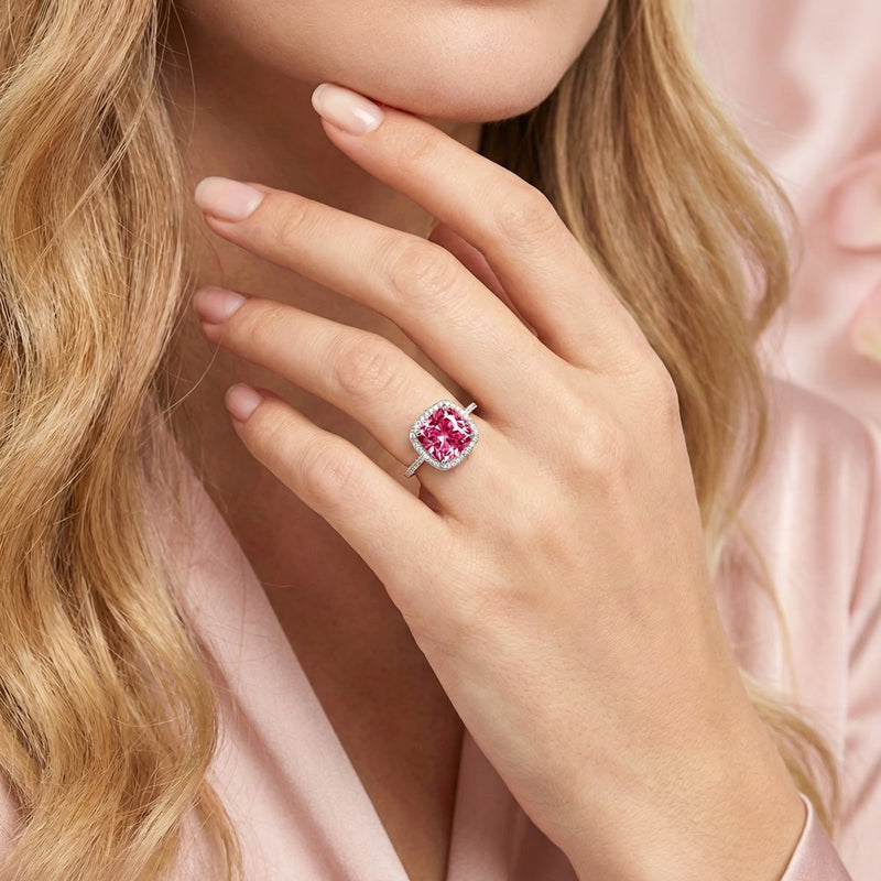 Sterling silver Rosamara halo ring with a cushion cut pink tourmaline worn on a model's hand.