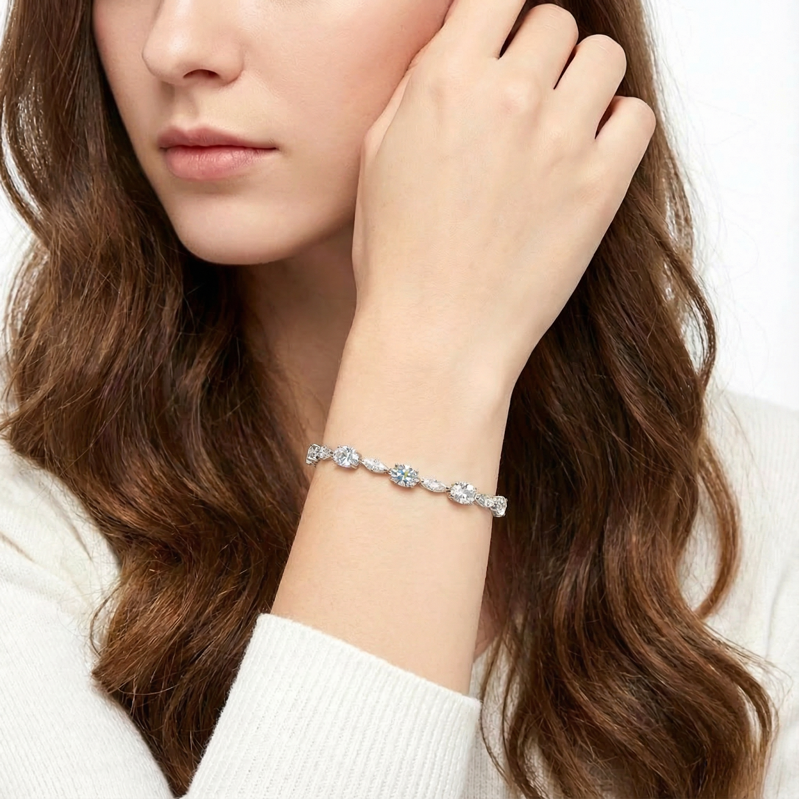 Woman wearing the Lysithea sterling silver bracelet with oval simulated diamonds on her wrist.