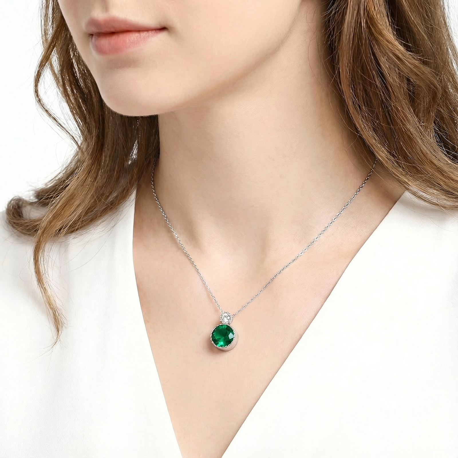 Model wearing the sterling silver Iseline drop necklace with a round-cut green simulated emerald.